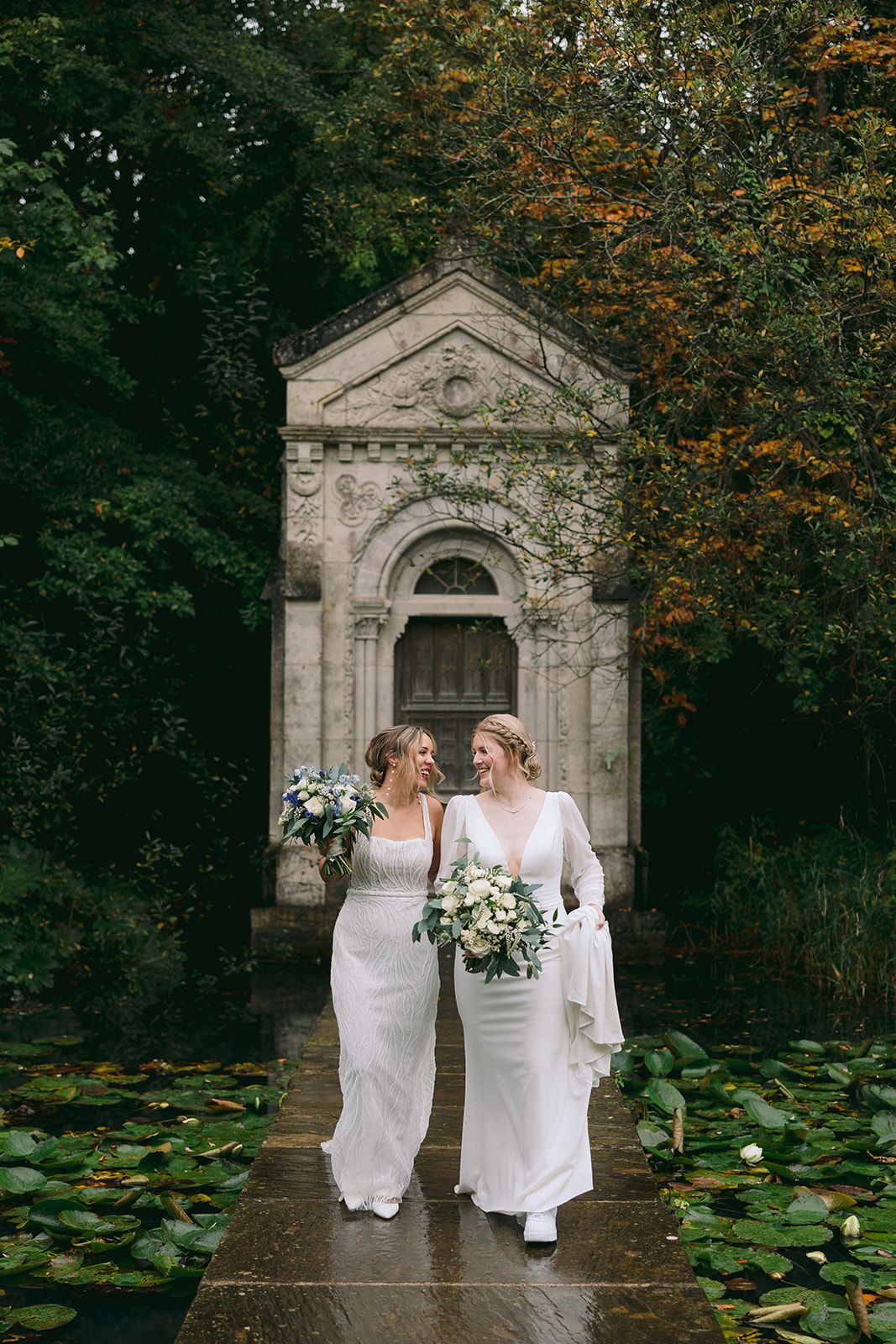 Two brides looking at each other in the middle of a boardwalk over a lake during their micro wedding in Ireland