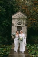 Two brides looking at each other in the middle of a boardwalk over a lake during their micro wedding in Ireland