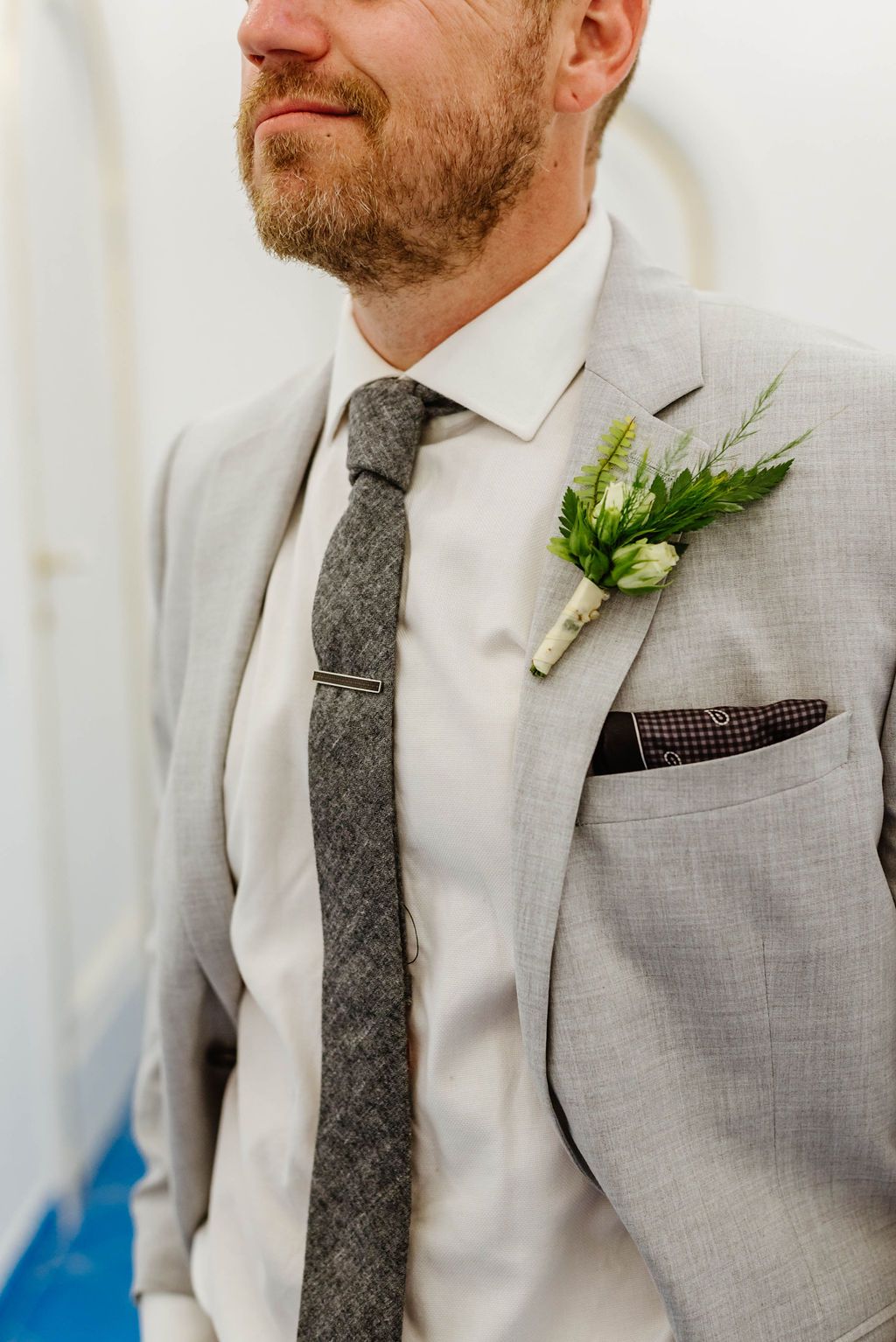 Groom detail with boutonniere, tie clip and tailored suit for an intimate wedding in Italy