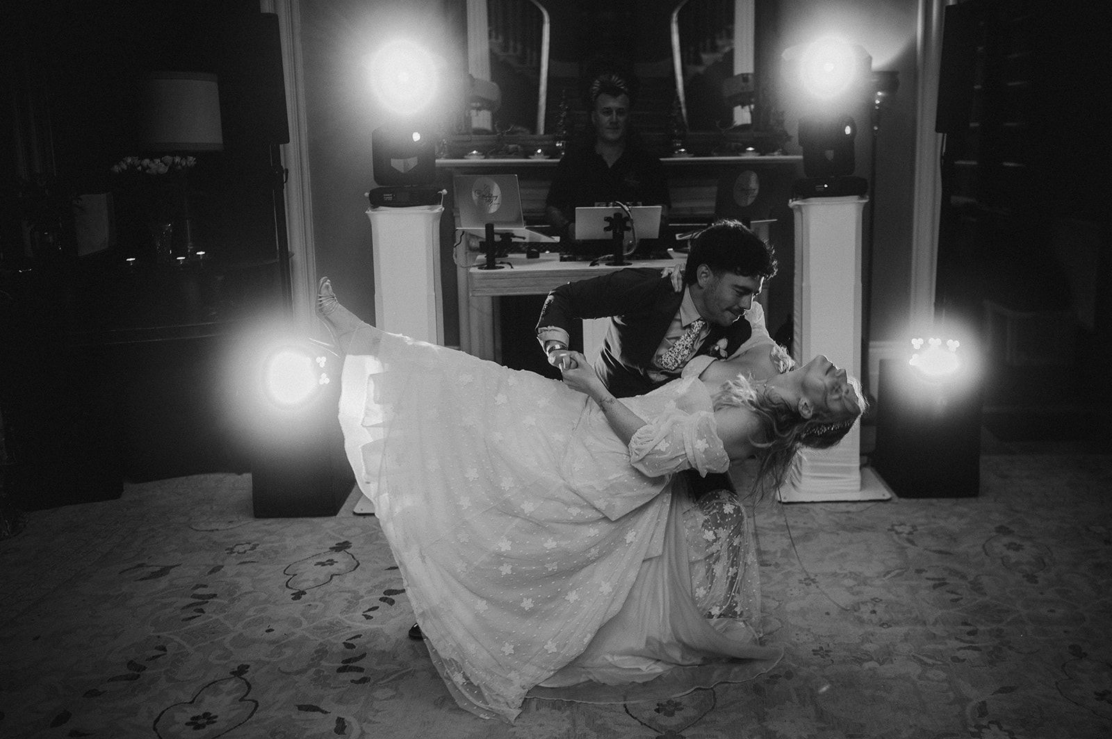 Groom dipping the bride during their first dance, black and white