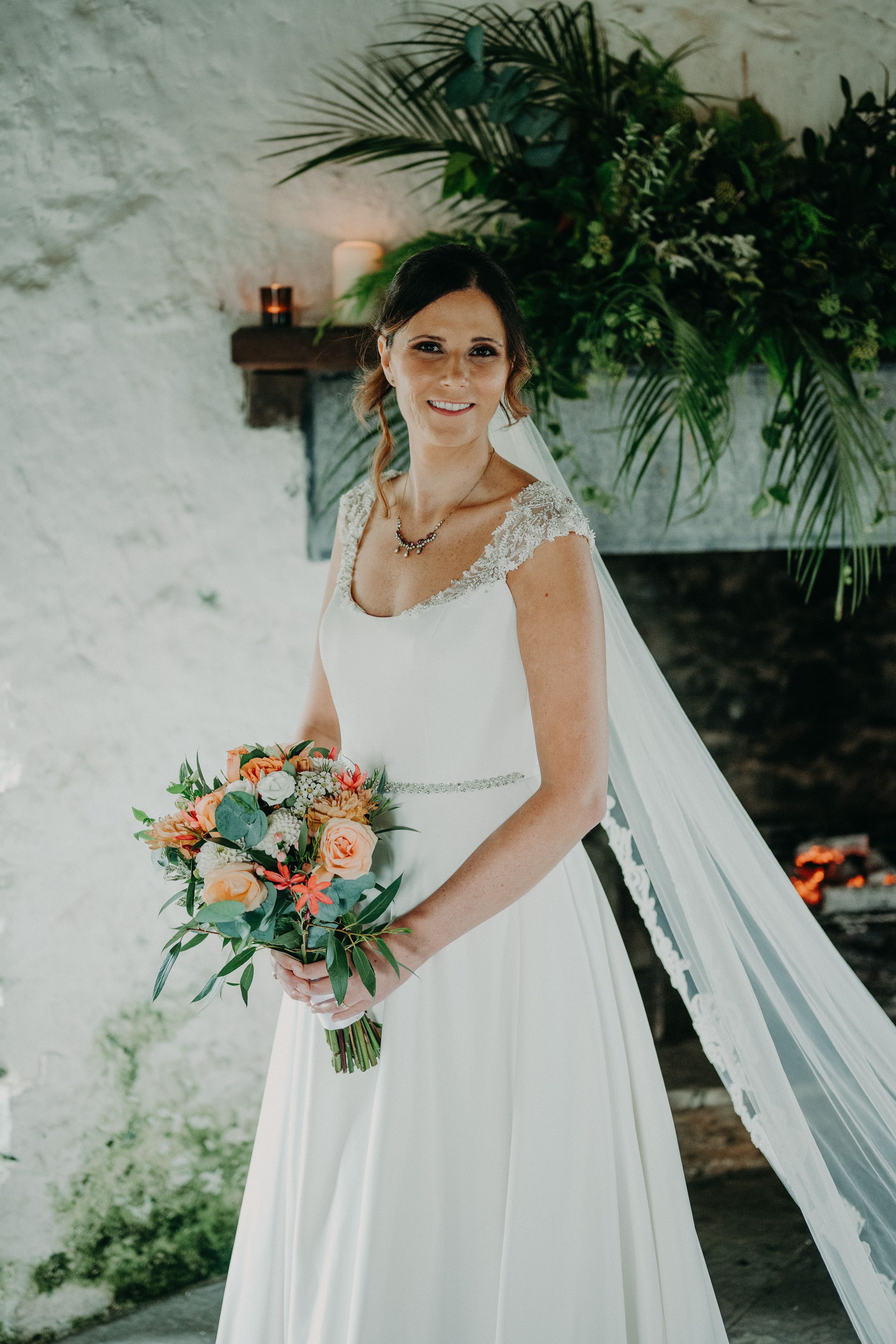 Bride holding a colorful bouquet inside a historic castle during an intimate wedding in Ireland.