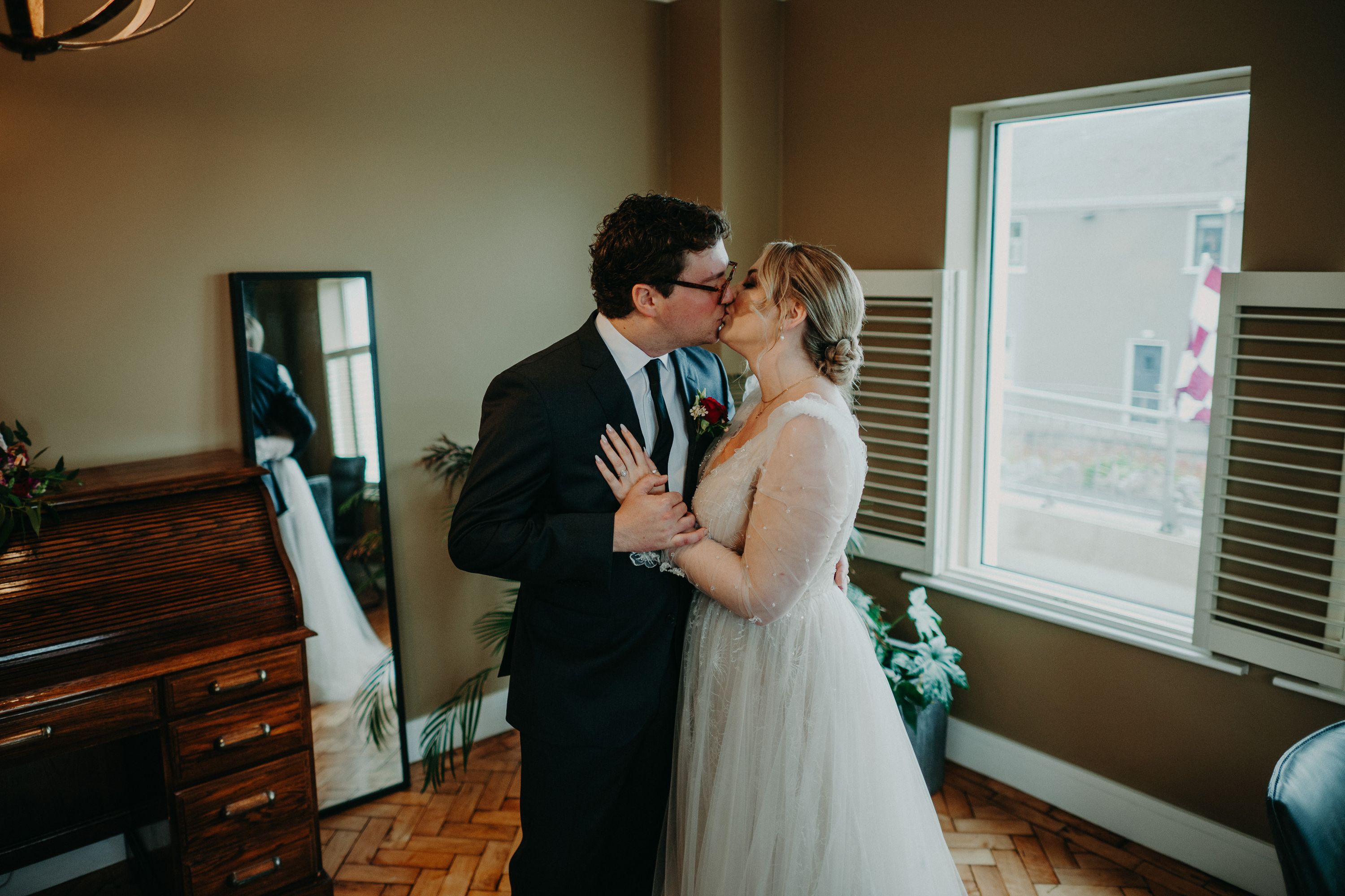Newlyweds sharing a kiss indoors after their emotional first look at a small wedding in Ireland