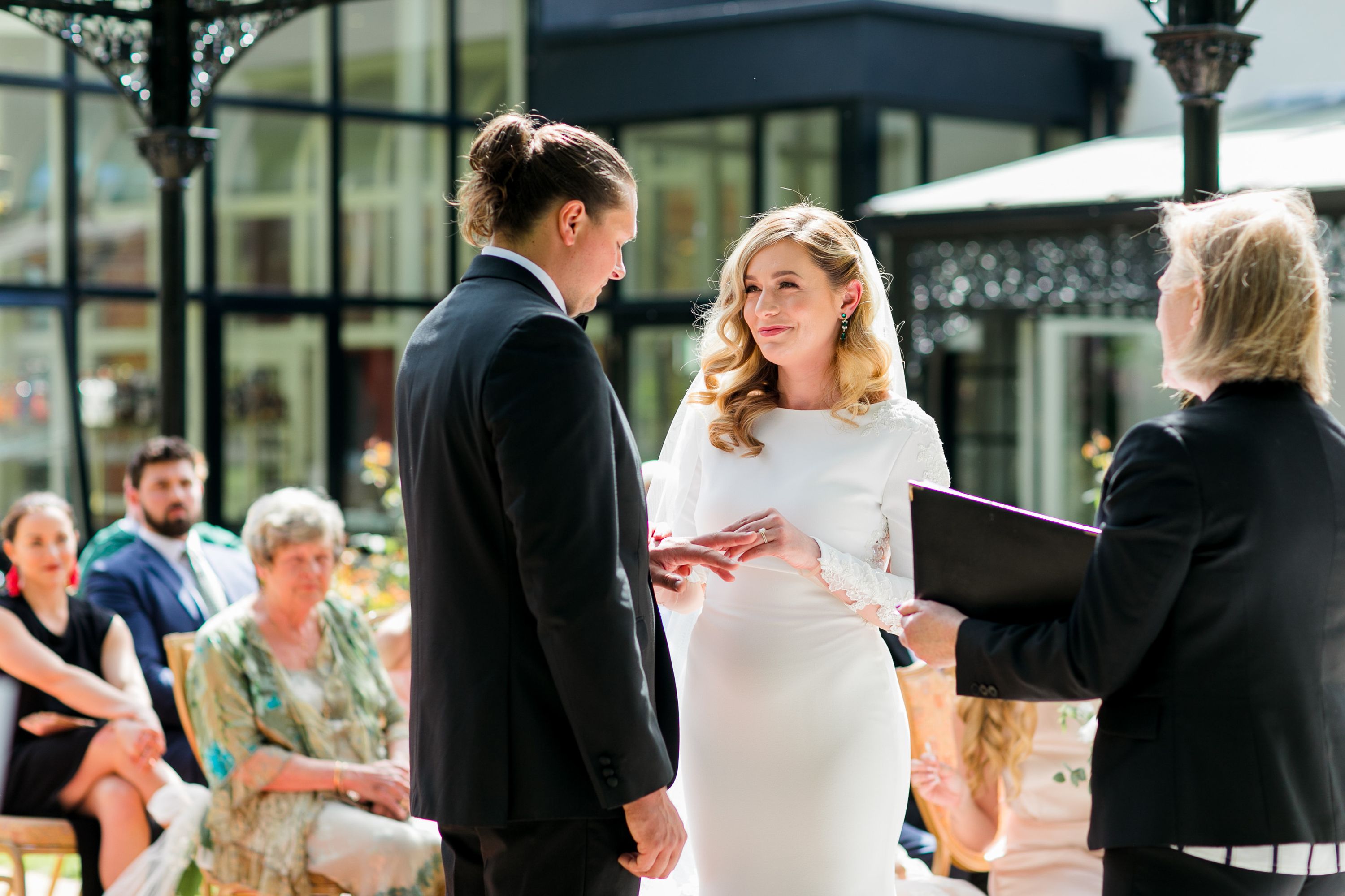 Bride and groom exchanging rings during an outdoor ceremony at a small wedding in Europe