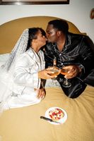 Newlyweds kissing while holding wine glasses in an Airbnb room after their elopement in Italy