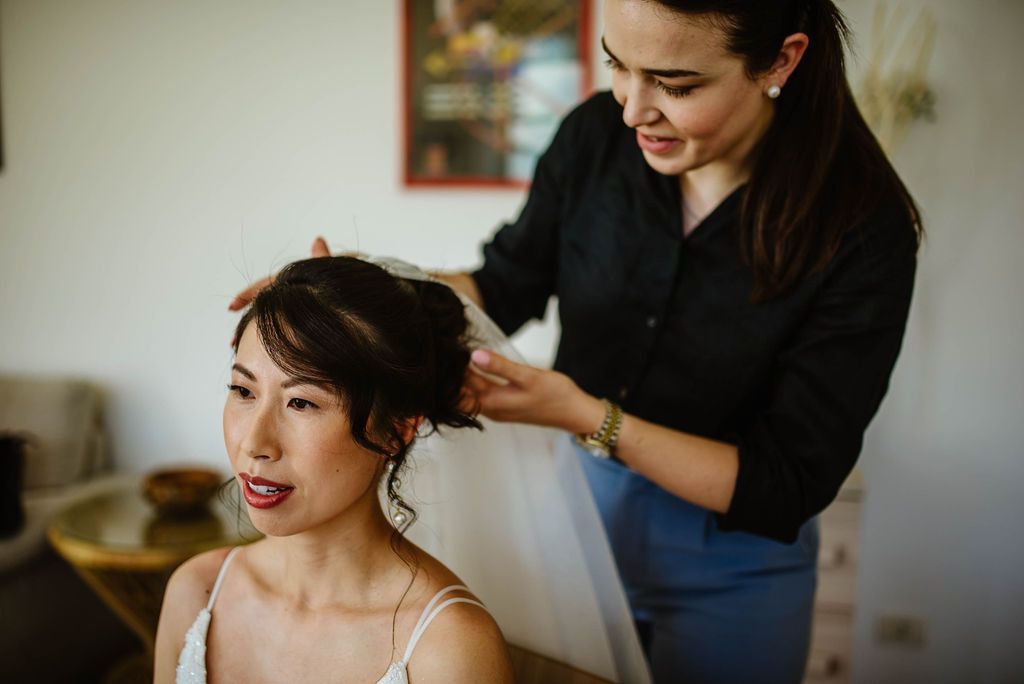Wedding planner fixing bride's veil at a wedding in Italy