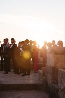 Wedding guests gathered in the castle's balcony for the drinks reception of a micro wedding in Portugal