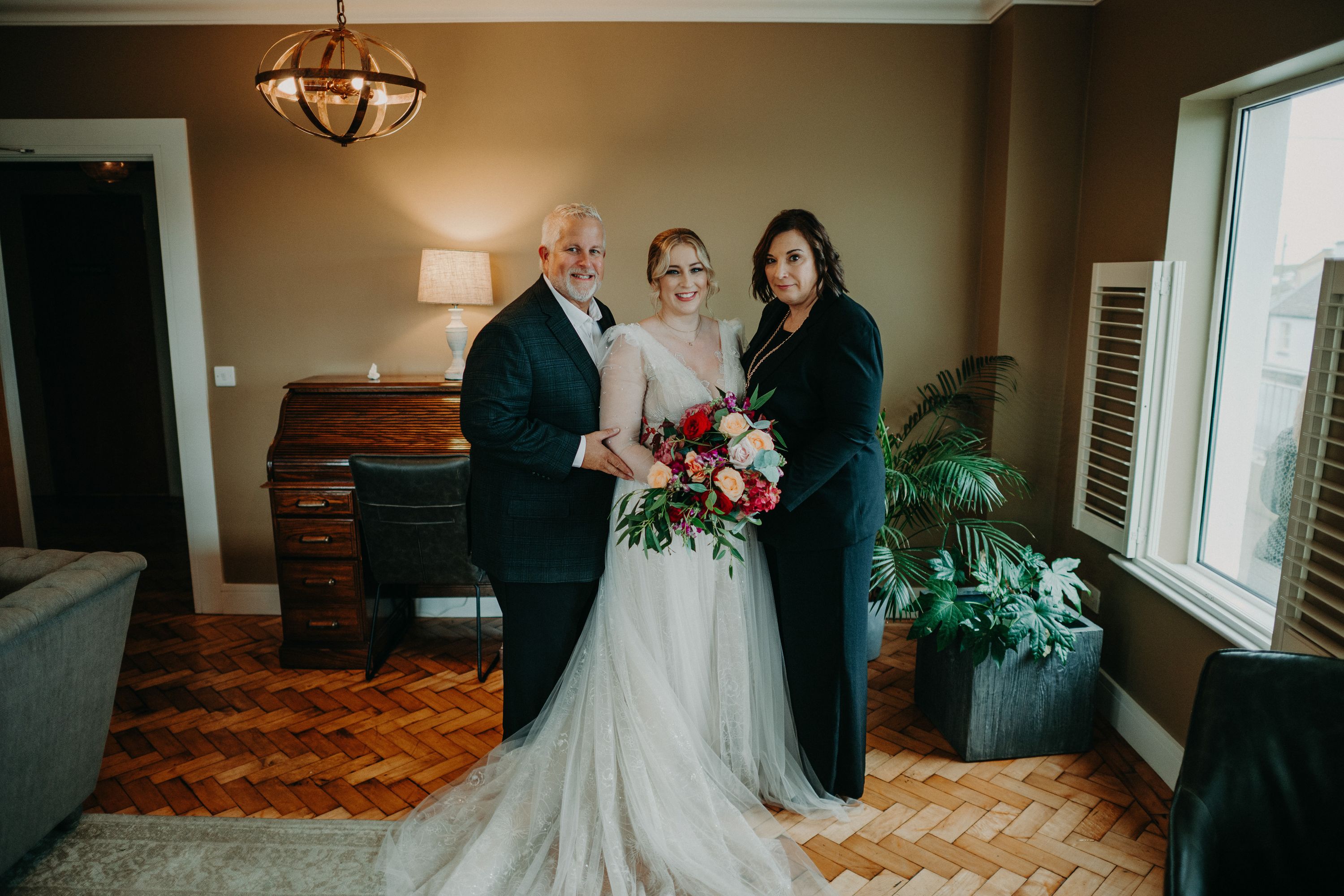 Bride posing with her parents before their intimate wedding in Ireland celebration