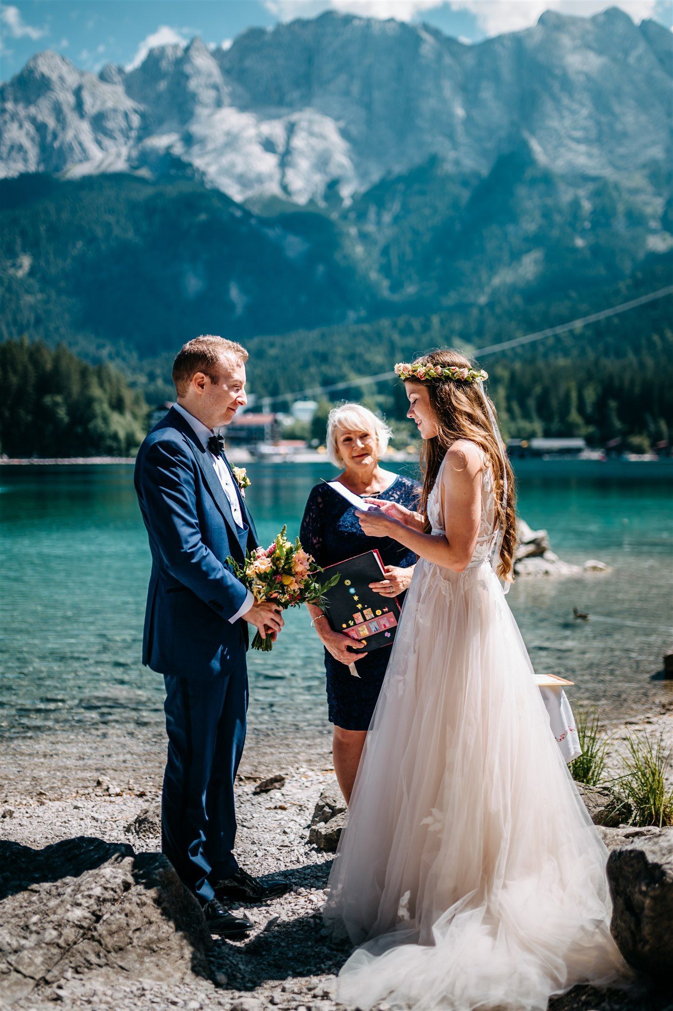 Bride and groom exchanging vows in front of a celebrant at their lake elopement in Germany