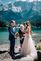 Bride and groom exchanging vows in front of a celebrant at their lake elopement in Germany