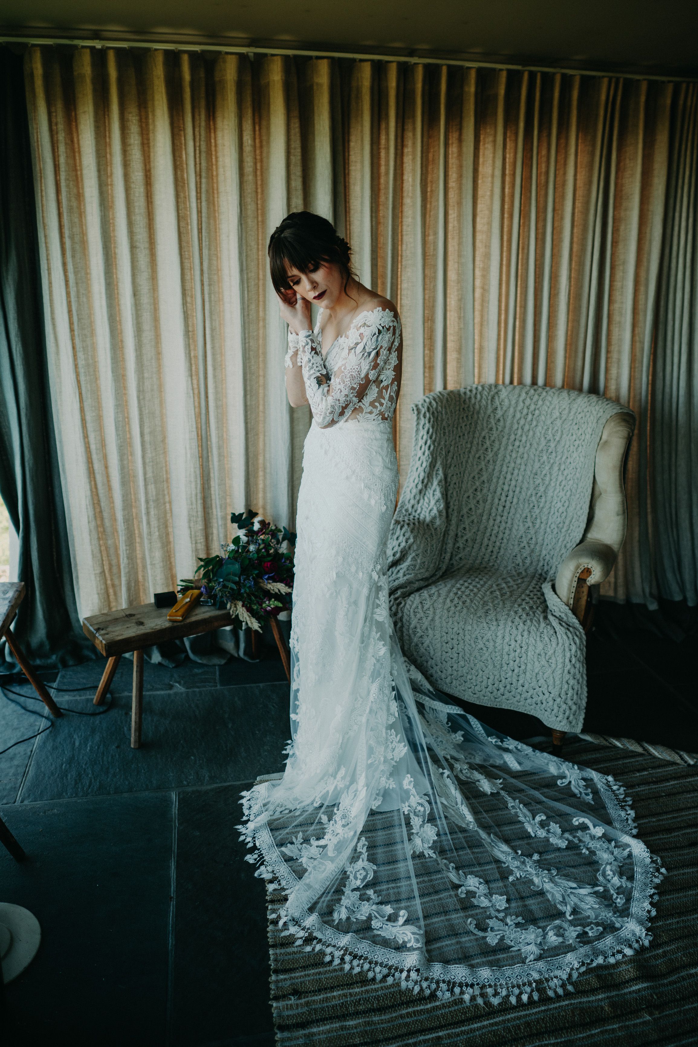 A bride fixing her outfit inside a cottage ahead of her small wedding in Ireland