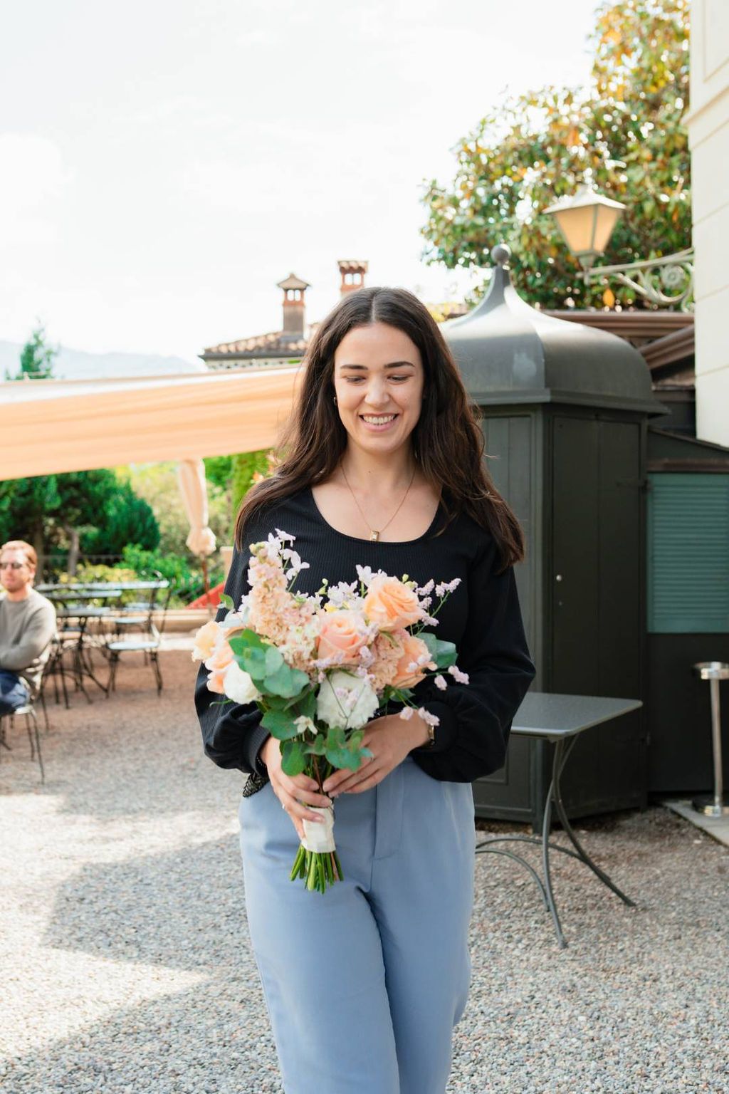 Our Italian wedding planner holding our bride's bouquet during a destination elopement in Italy