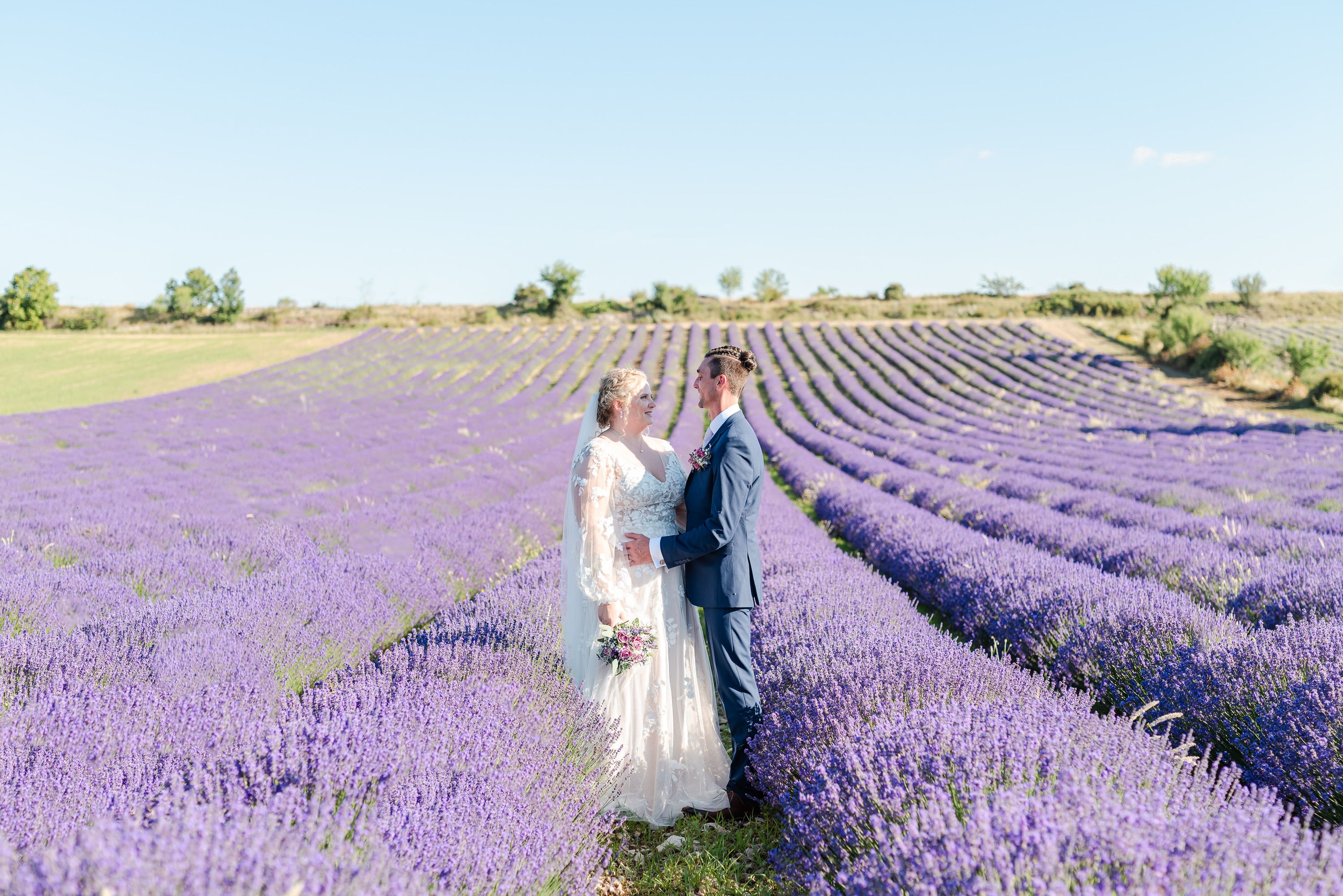 Bride and groom standing among lavender fields during an intimate wedding in France