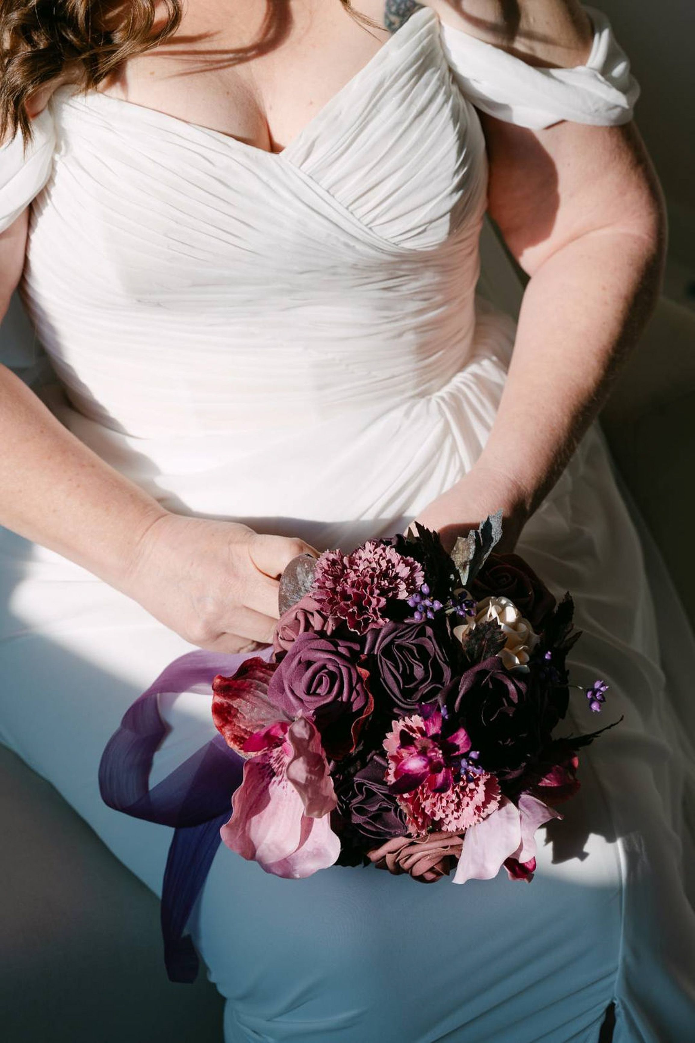 Bride holding a purple bouquet while seated in her wedding gown for a small wedding in Italy