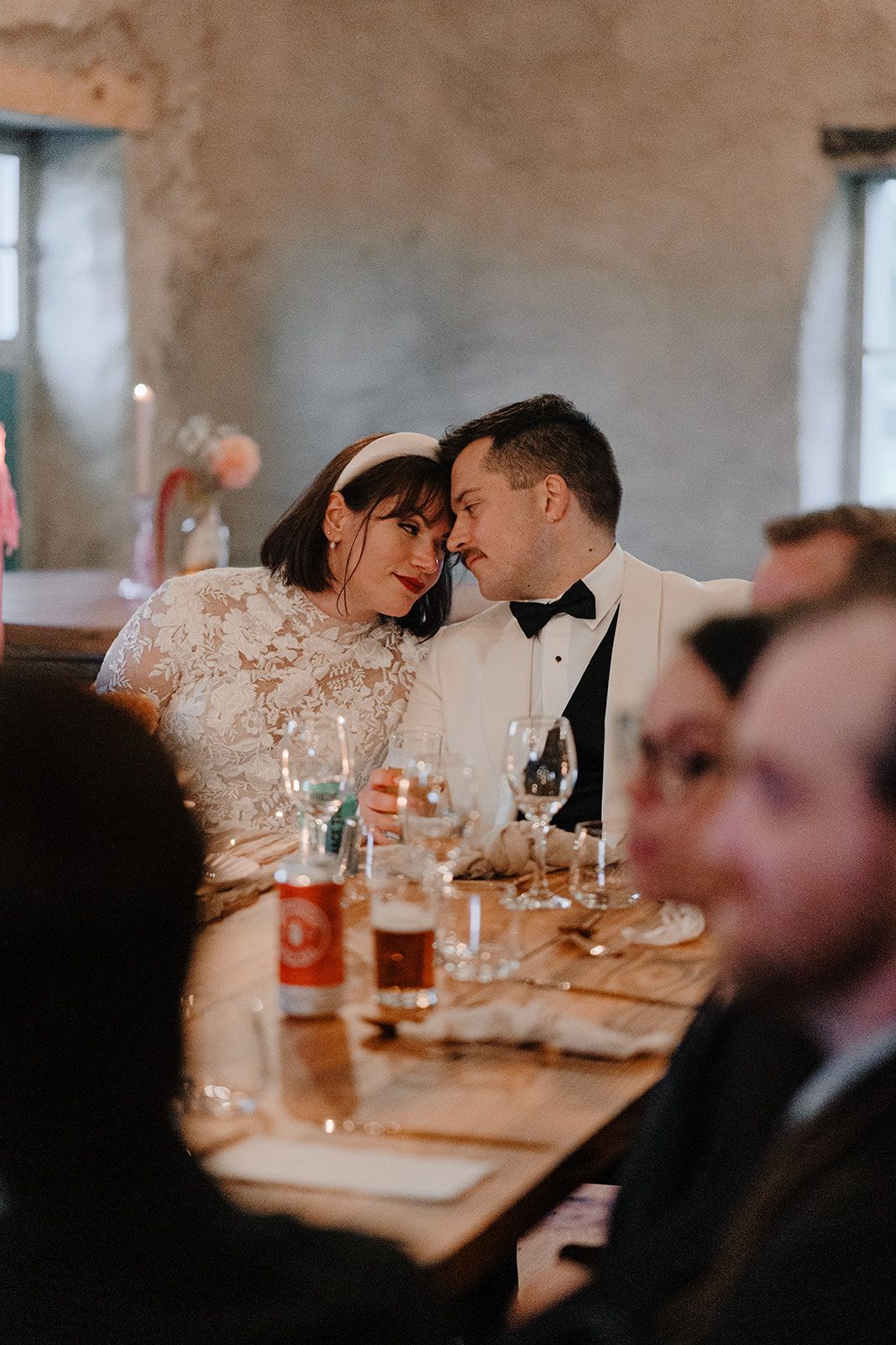 Bride and groom with heads leaning on each other during the reception of their destination wedding in Ireland