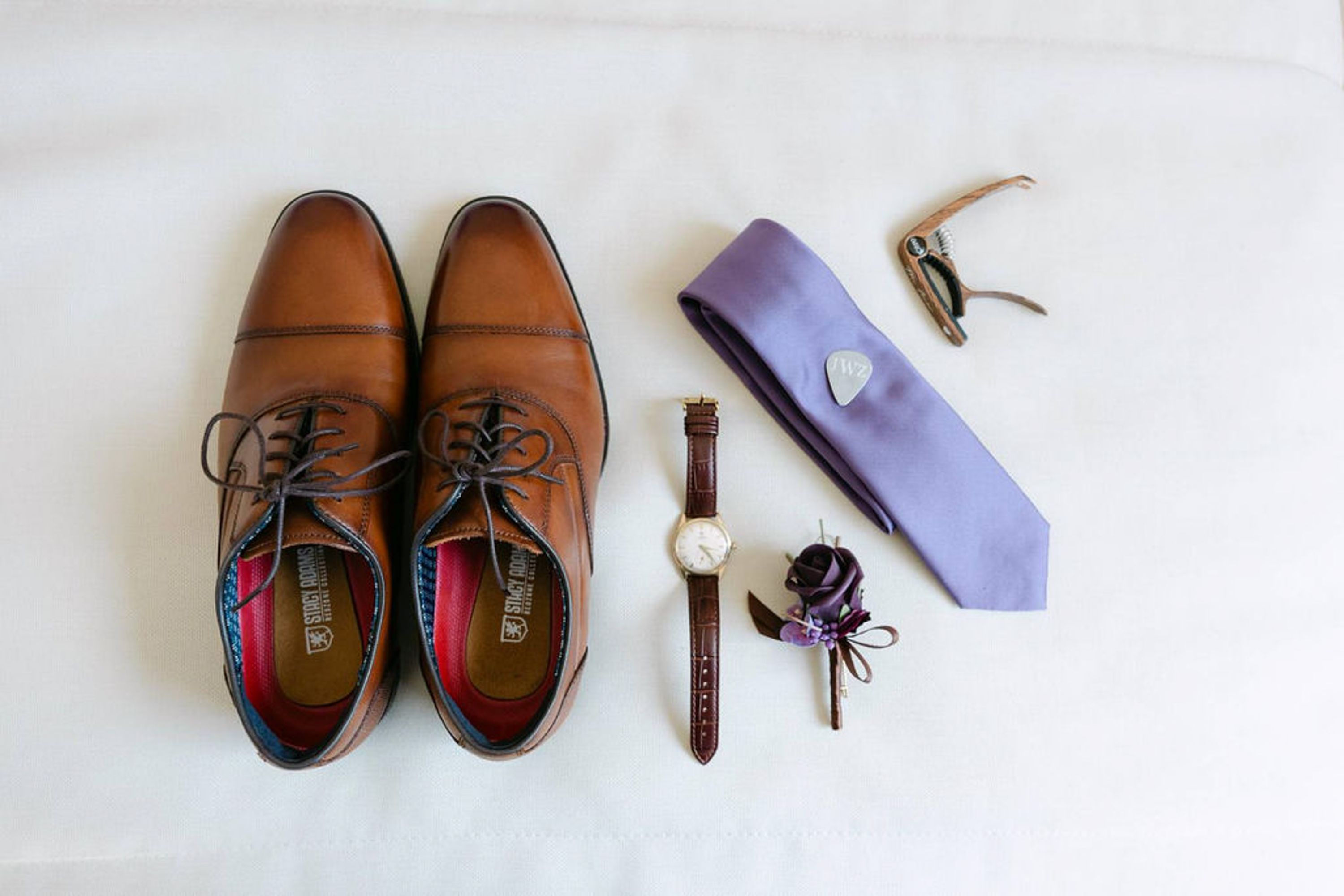 Groom accessories including shoes, tie, watch and boutonniere prepared for an intimate wedding in Italy