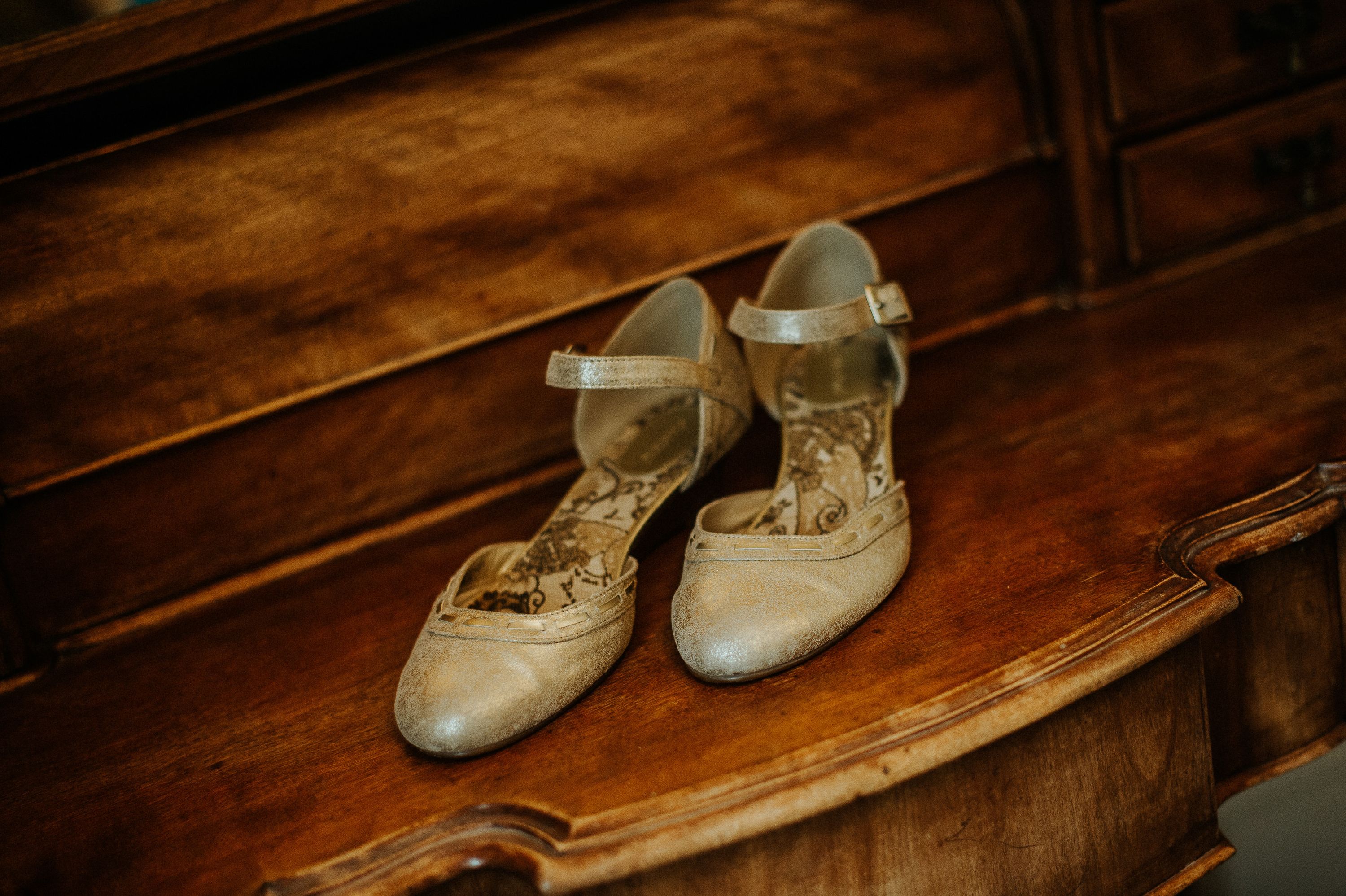 Vintage-inspired bridal shoes displayed on a wooden dresser for a small wedding in Portugal