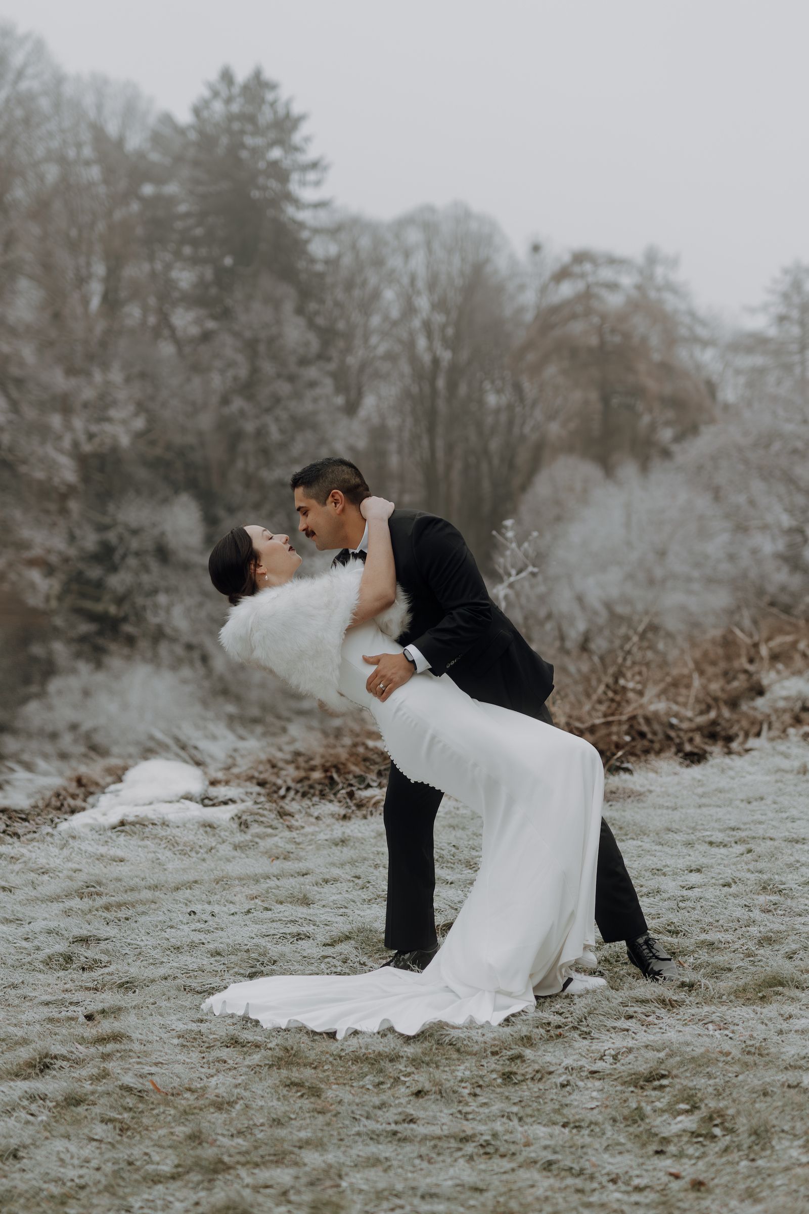 Newlyweds romantically looking at each other in the middle of a German forest in winter 