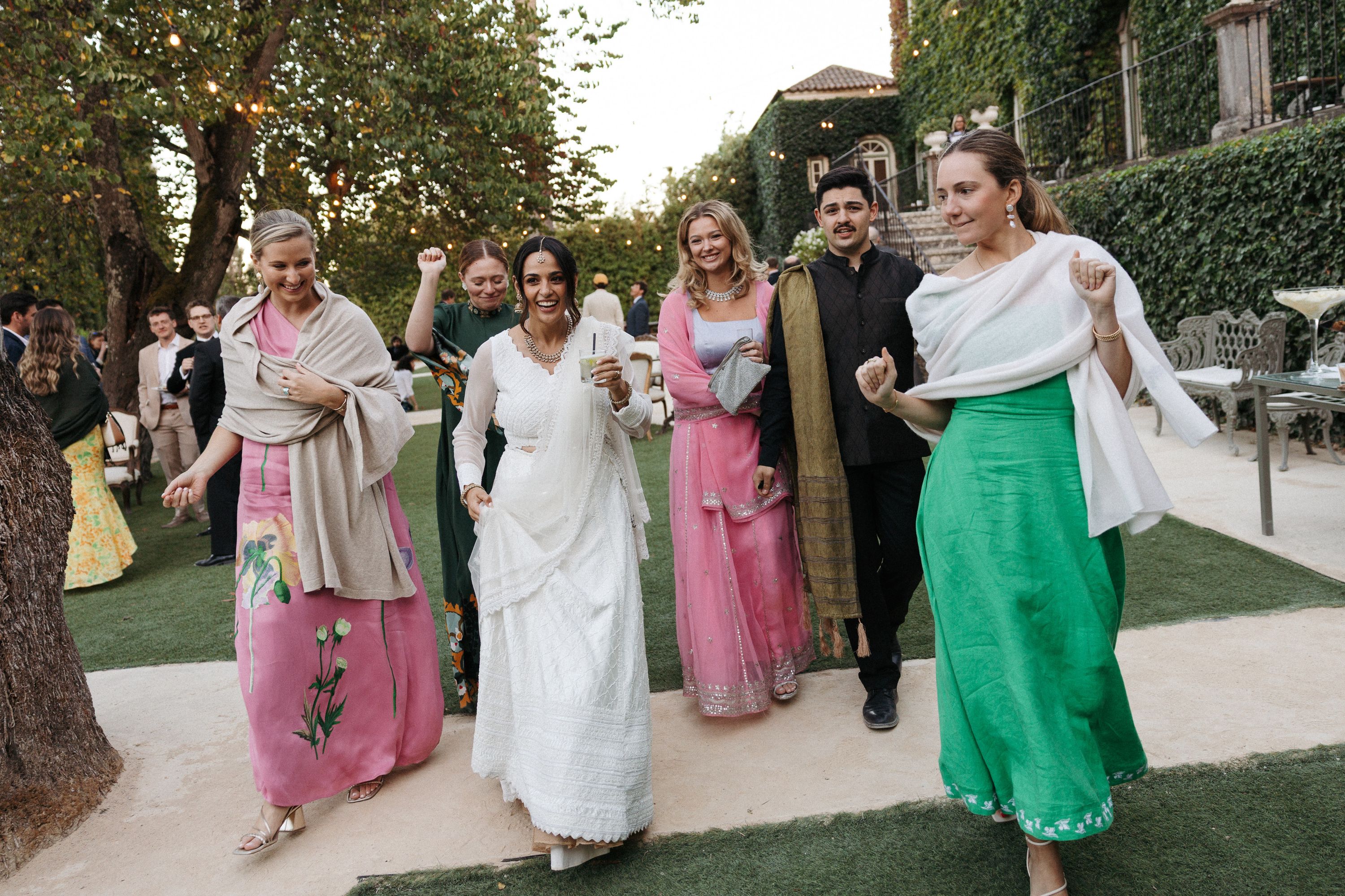 Wedding guests in colorful attire dancing outdoors at an intimate wedding in Portugal