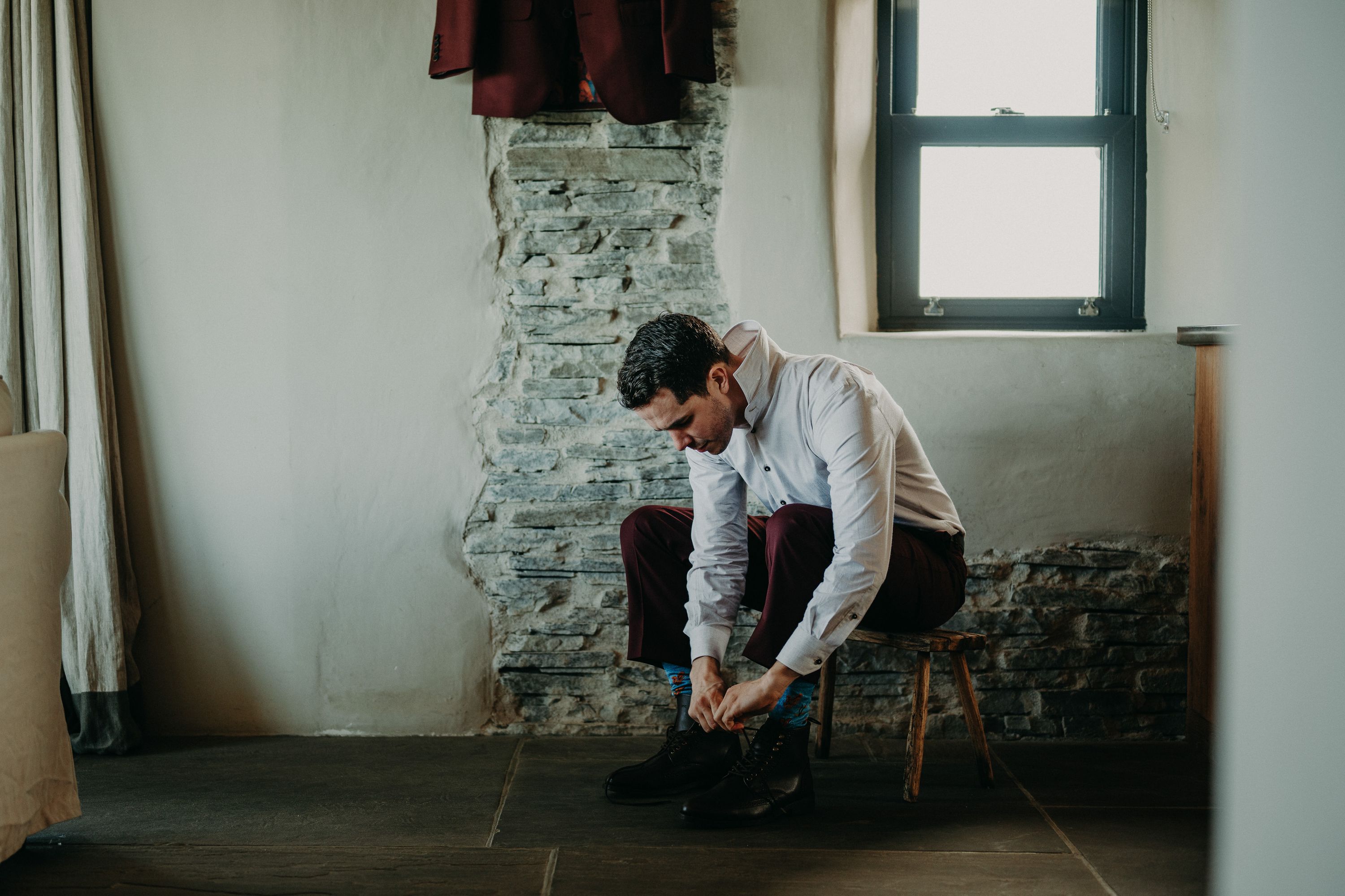 A groom preparing inside a fairytale cottage before his intimate wedding in Ireland