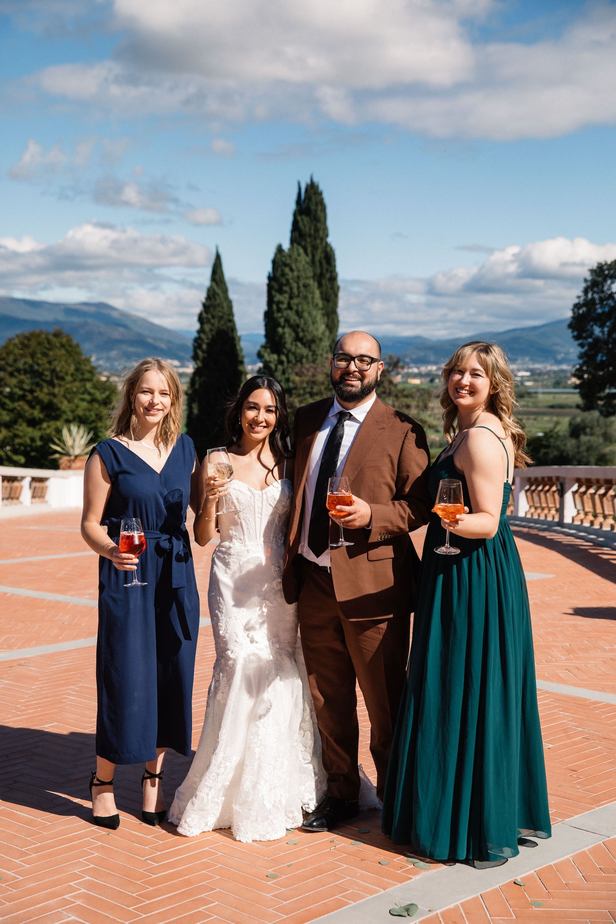 Bride poses for a photo during the drinks reception of their vow renewal in Italy with the Florence skyline in the background
