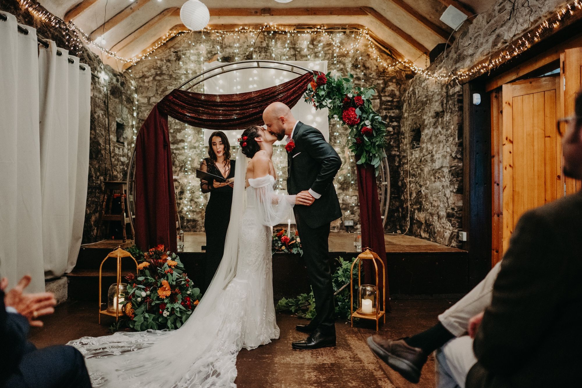 Bride and groom kiss in front of their guests on their small wedding in Ireland at an traditional pub