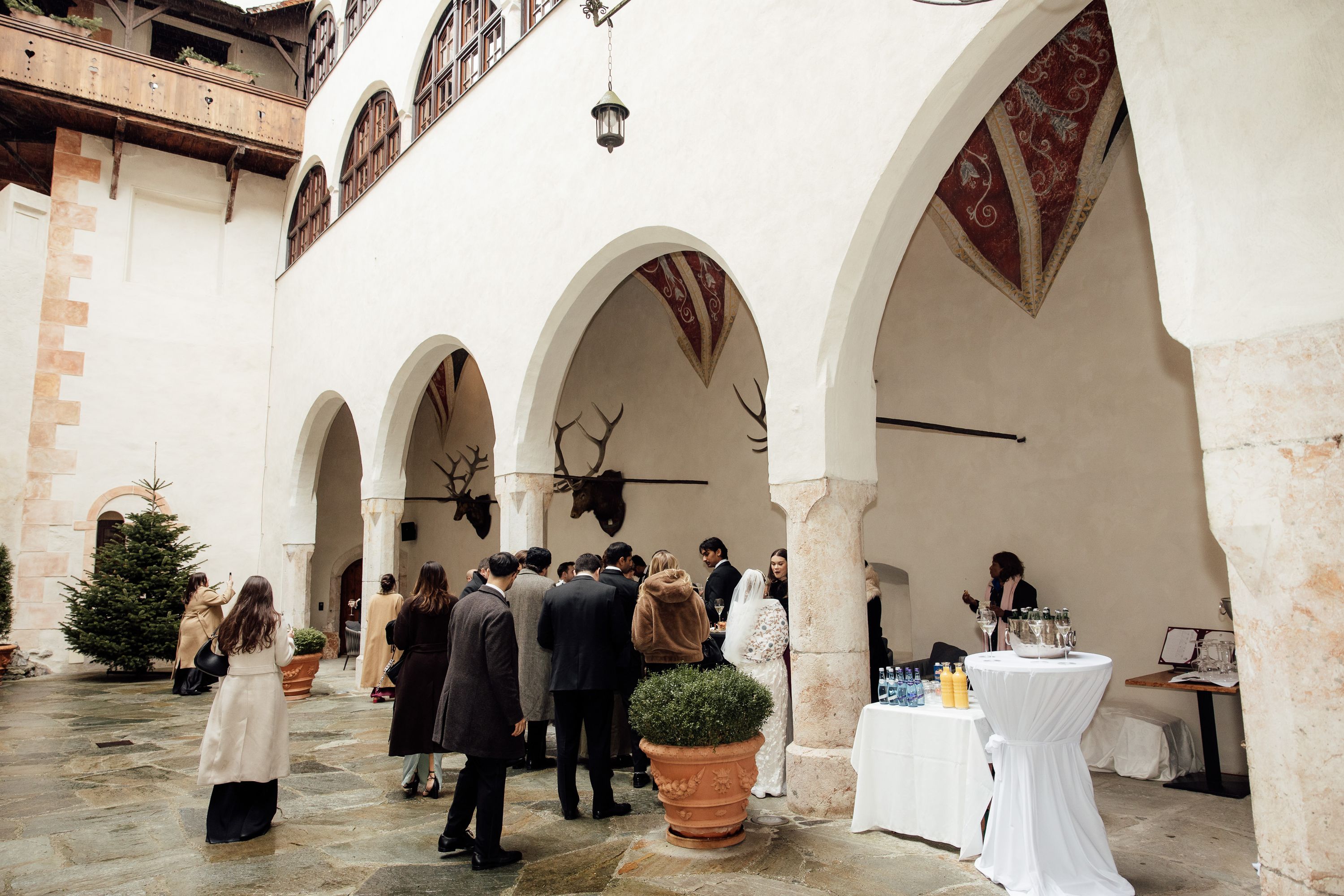 Guests gather in a castle courtyard reception space during a small wedding in Austria