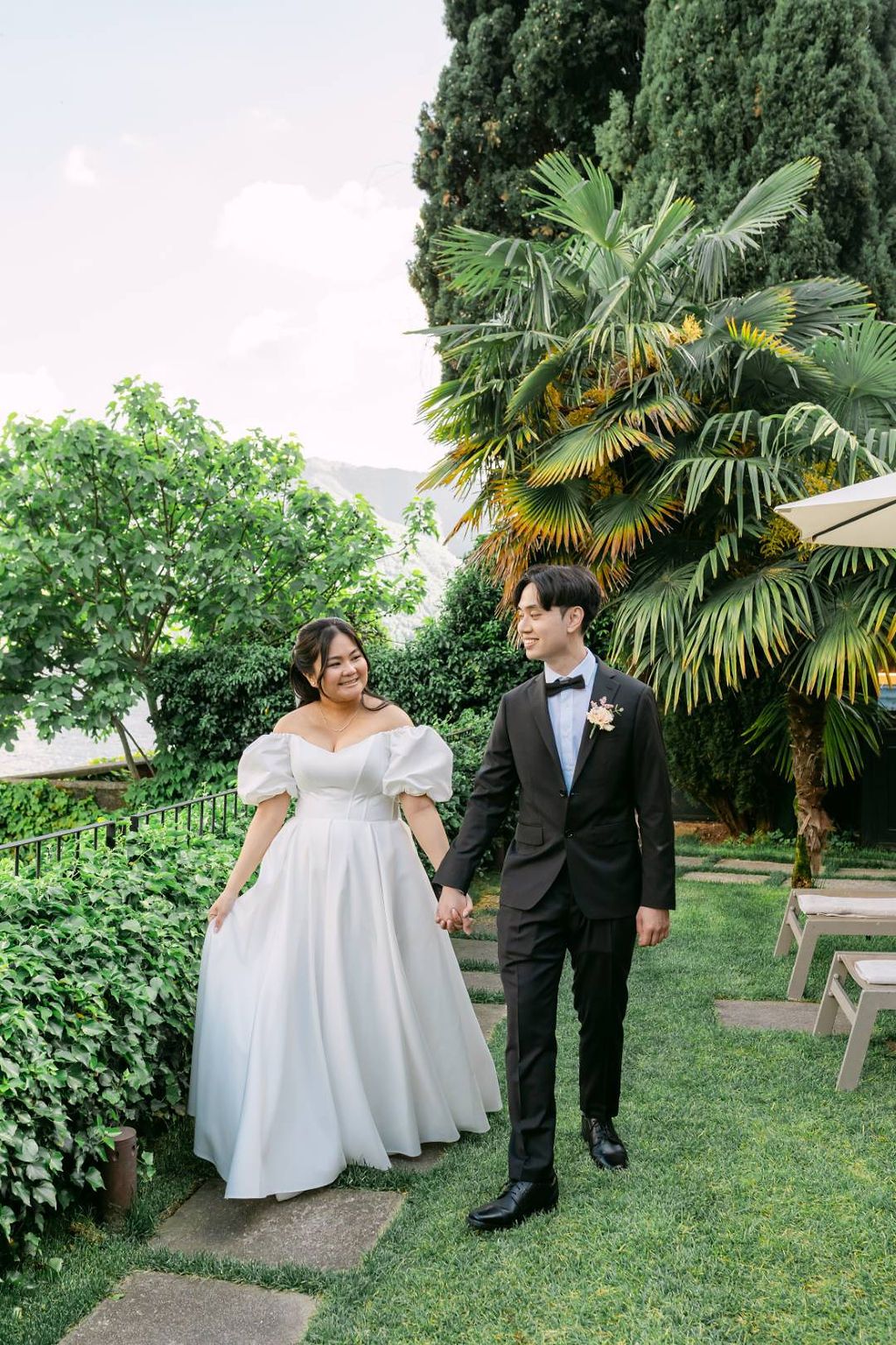 Bride and groom walking along the garden of the villa where they had an elopement in Italy