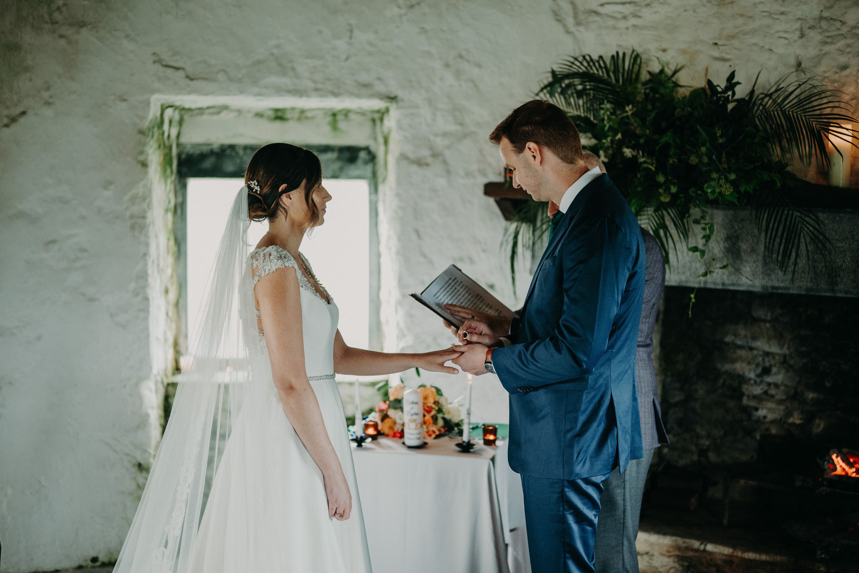 Bride and groom hold hands during a small wedding in Ireland inside a historic castle venue.