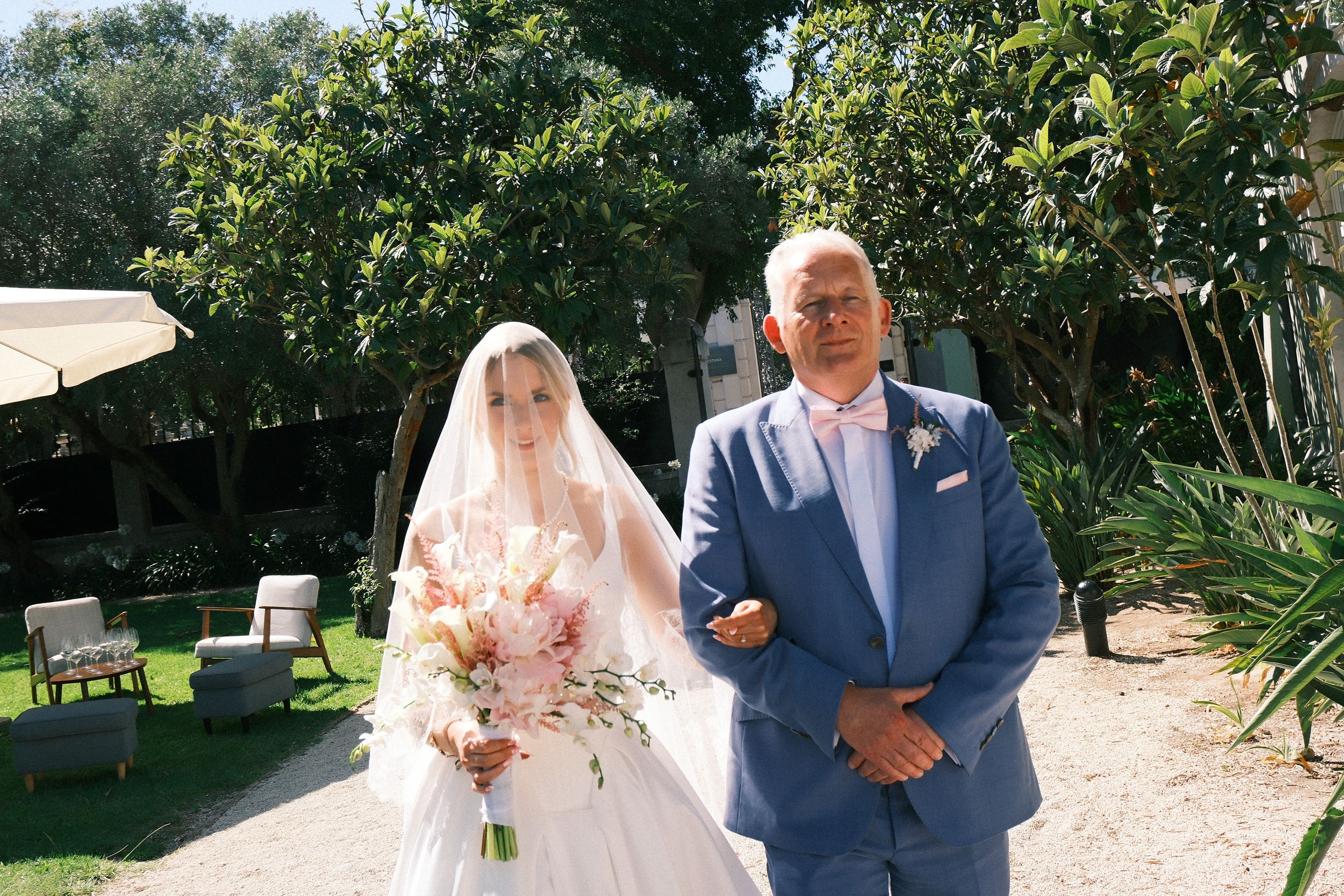 Bride walks with her father to the ceremony during an intimate wedding in Portugal