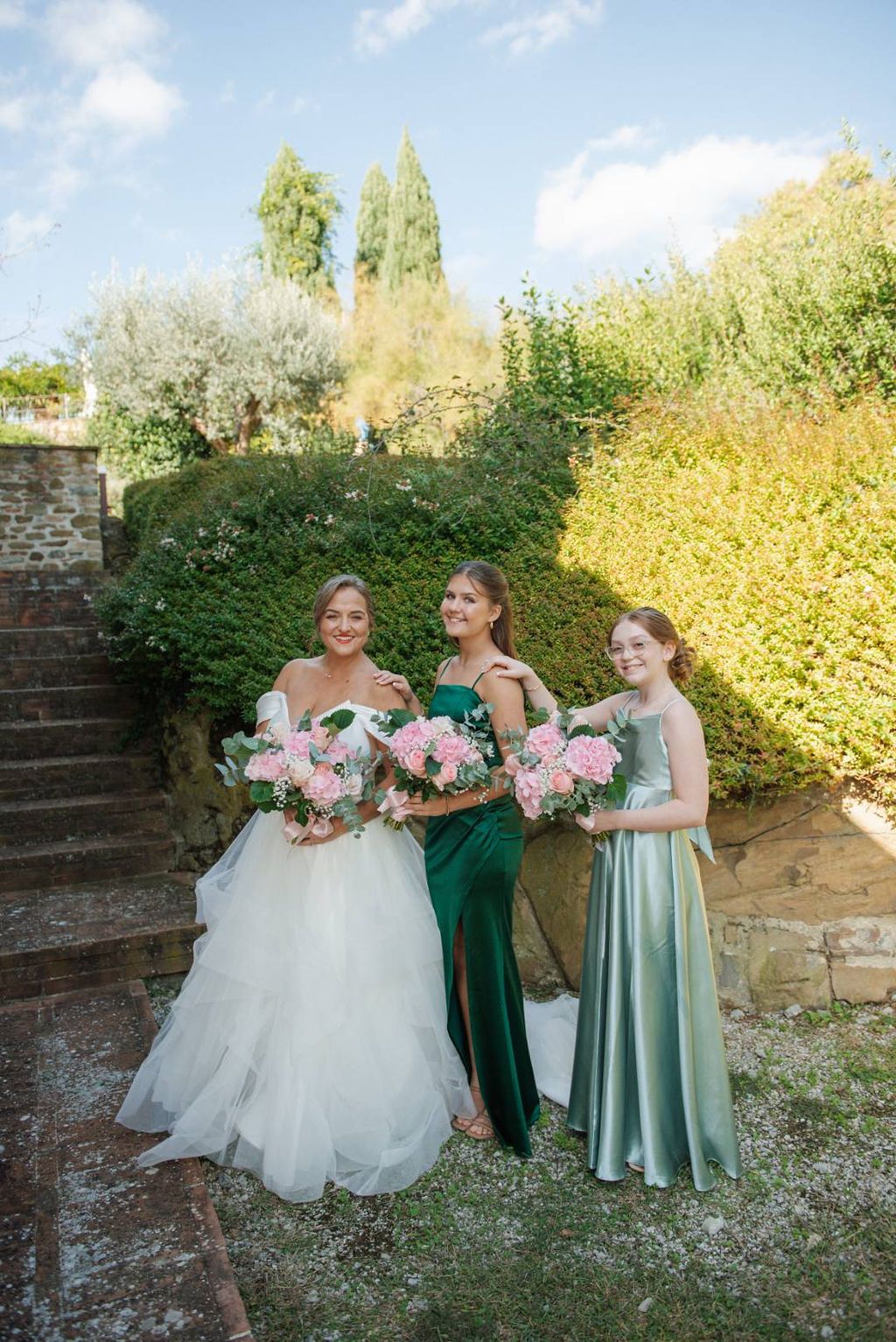 Bride with bridesmaids holding pink bouquets with eucalyptus leaves for their small wedding in Italy