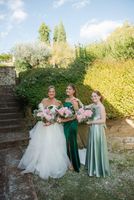 Bride with bridesmaids holding pink bouquets with eucalyptus leaves for their small wedding in Italy