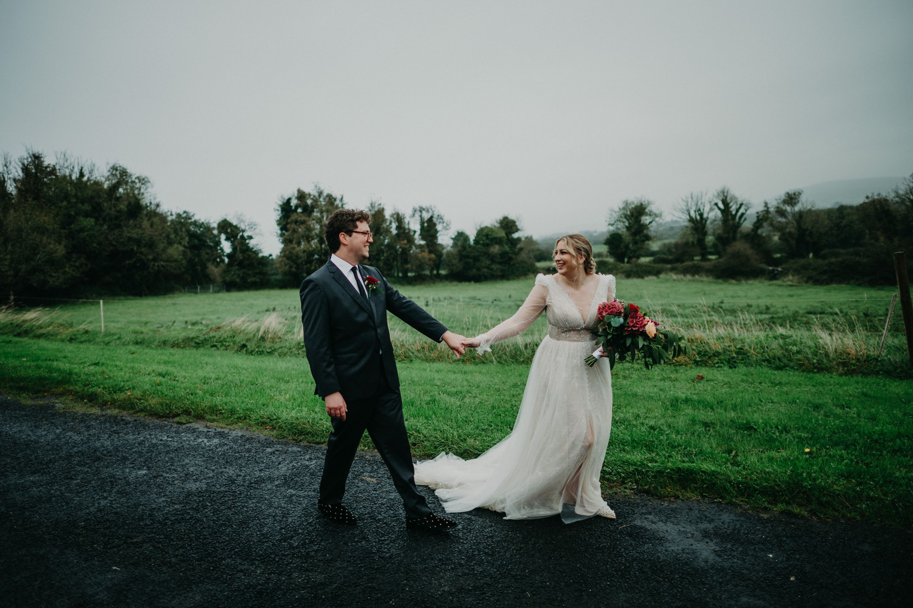 Bride and groom laughing together in the countryside after an intimate wedding in Ireland