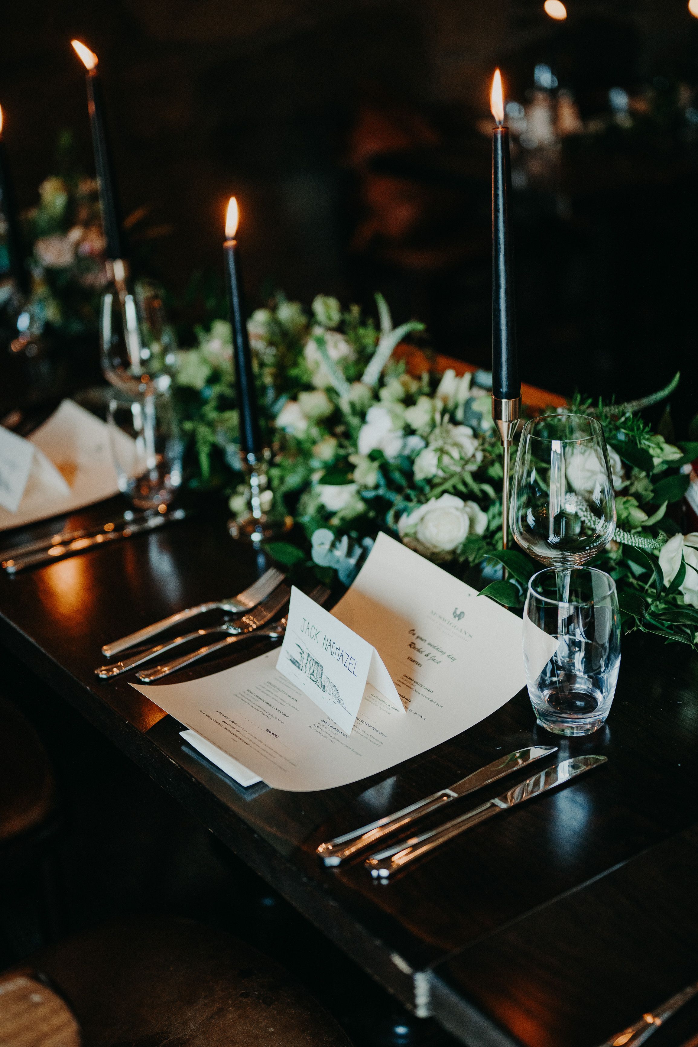 A table setup filled with leaves, candles, glasses, and a menu for a reception party after a small wedding in Ireland