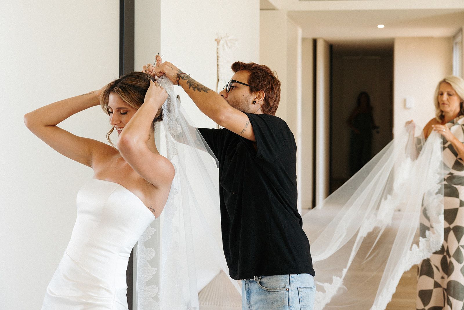 Bride in her wedding dress with a woman fixing her veil for her destination wedding in Portugal