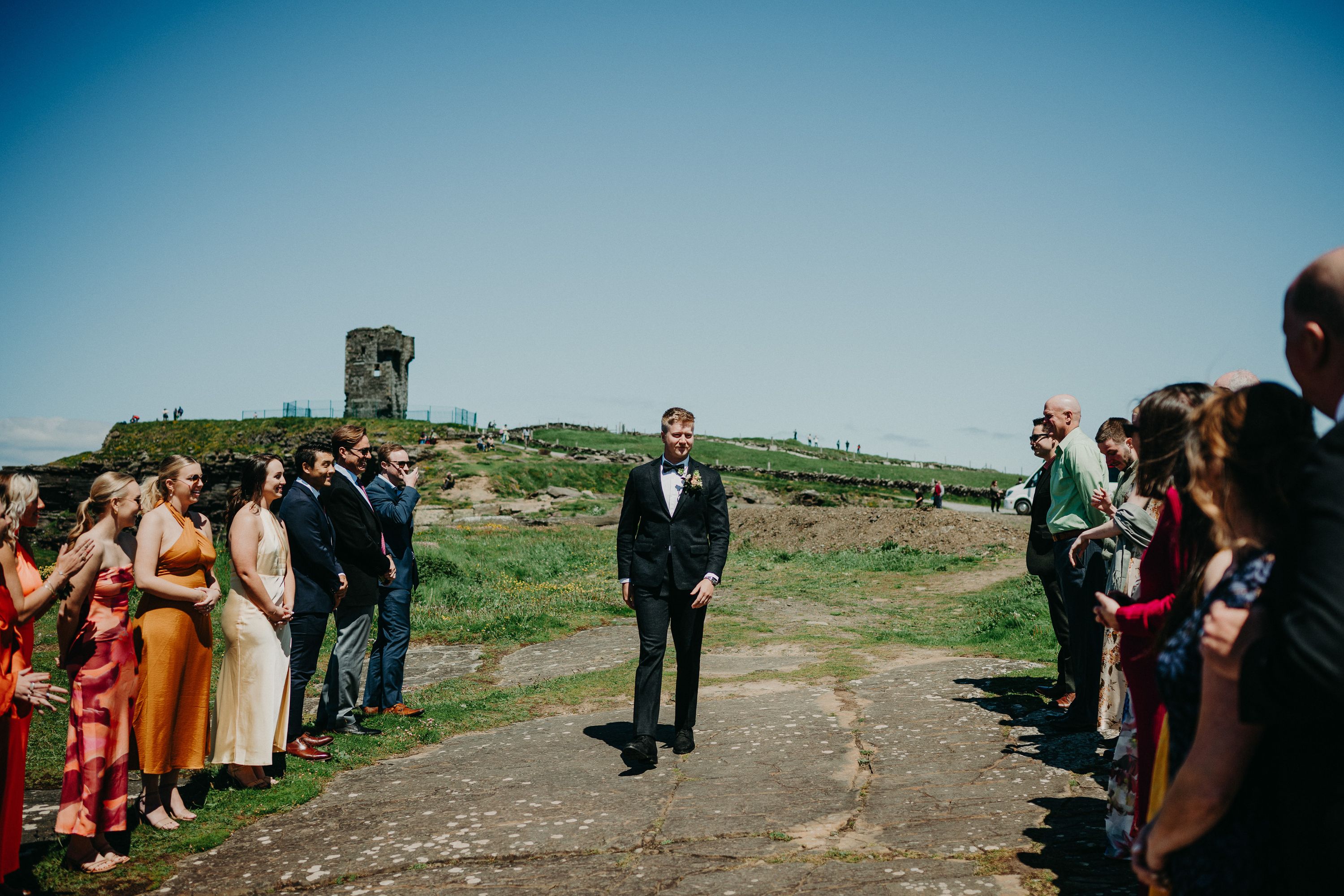 A groom walking while his friends and family look on during their intimate wedding in Ireland