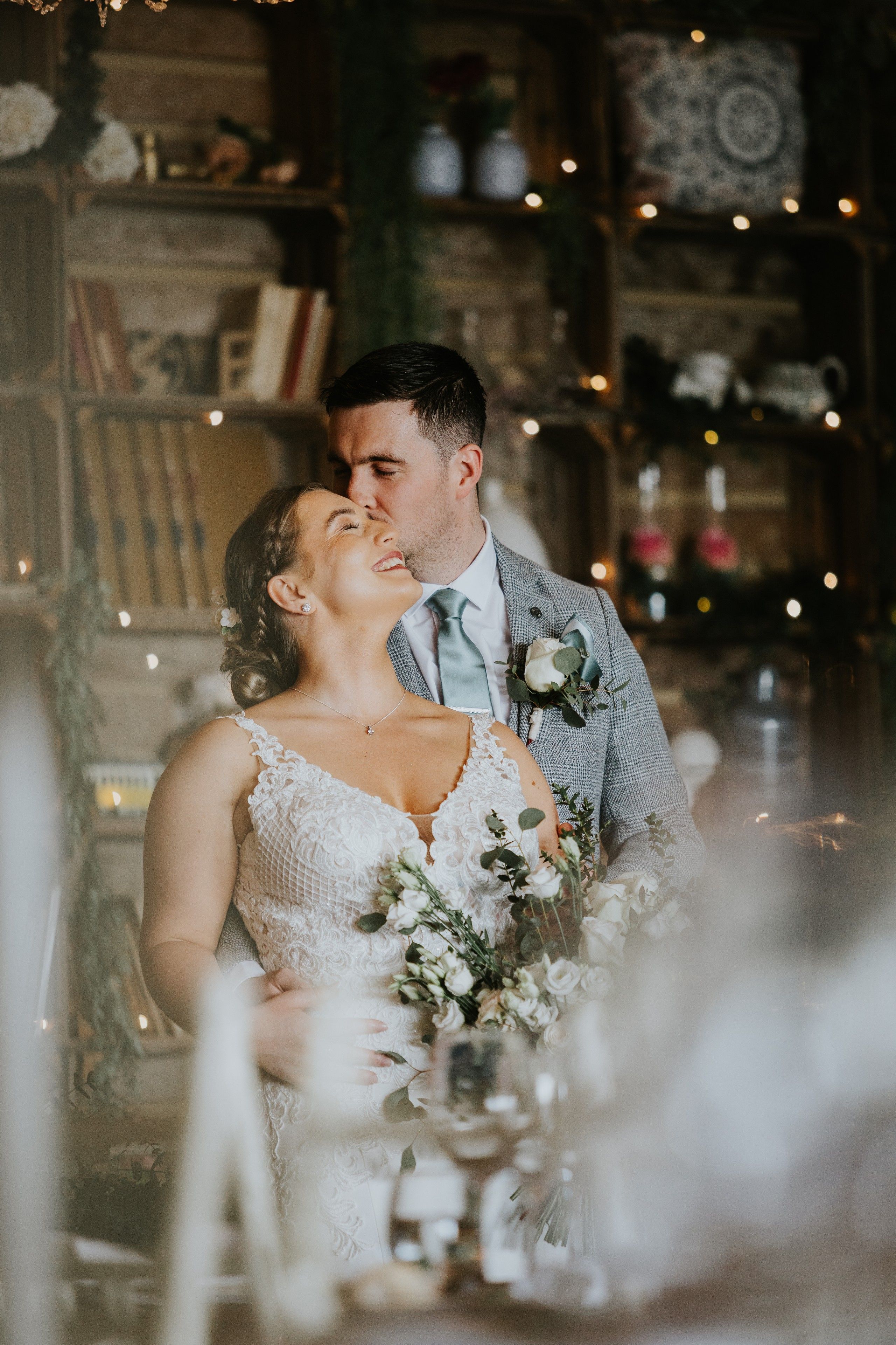 Newlyweds look at each other romantically in front of a rustic wooden plant house during their small wedding in Portugal