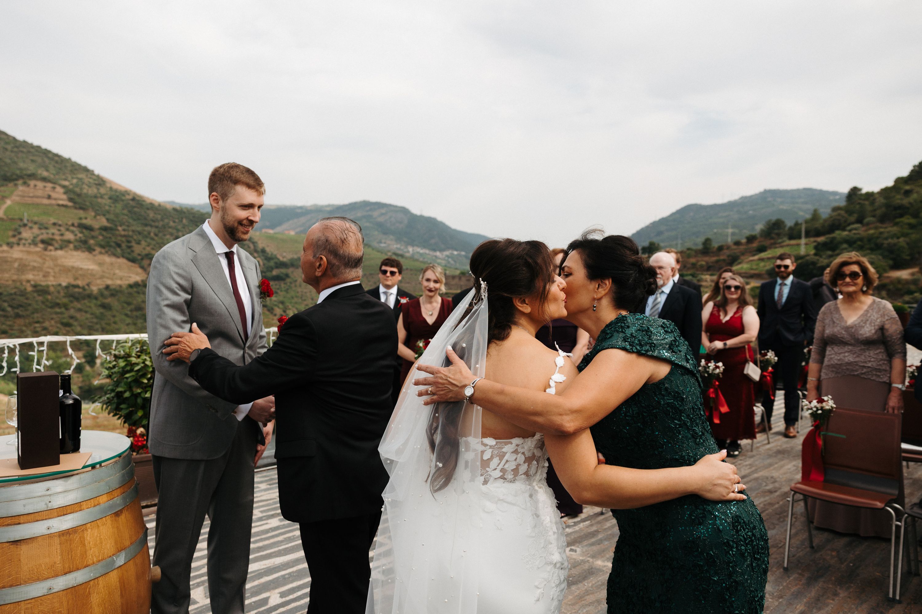 Wedding guests greeting the groom outdoors under sunny skies at an intimate wedding in Portugal