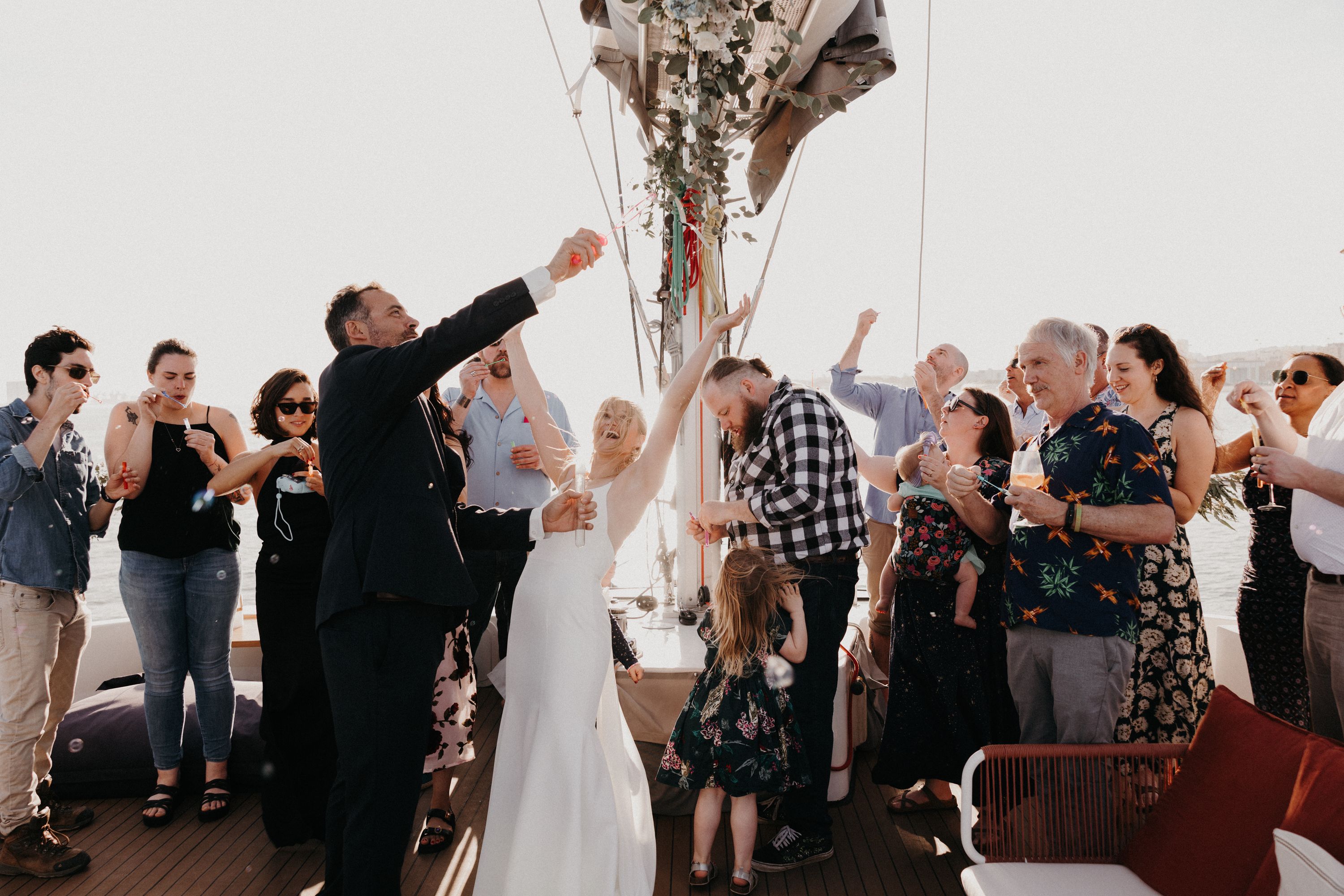 Bride throws her bouquet, with her groom and their guests celebrating with her during their destination wedding in Portugal