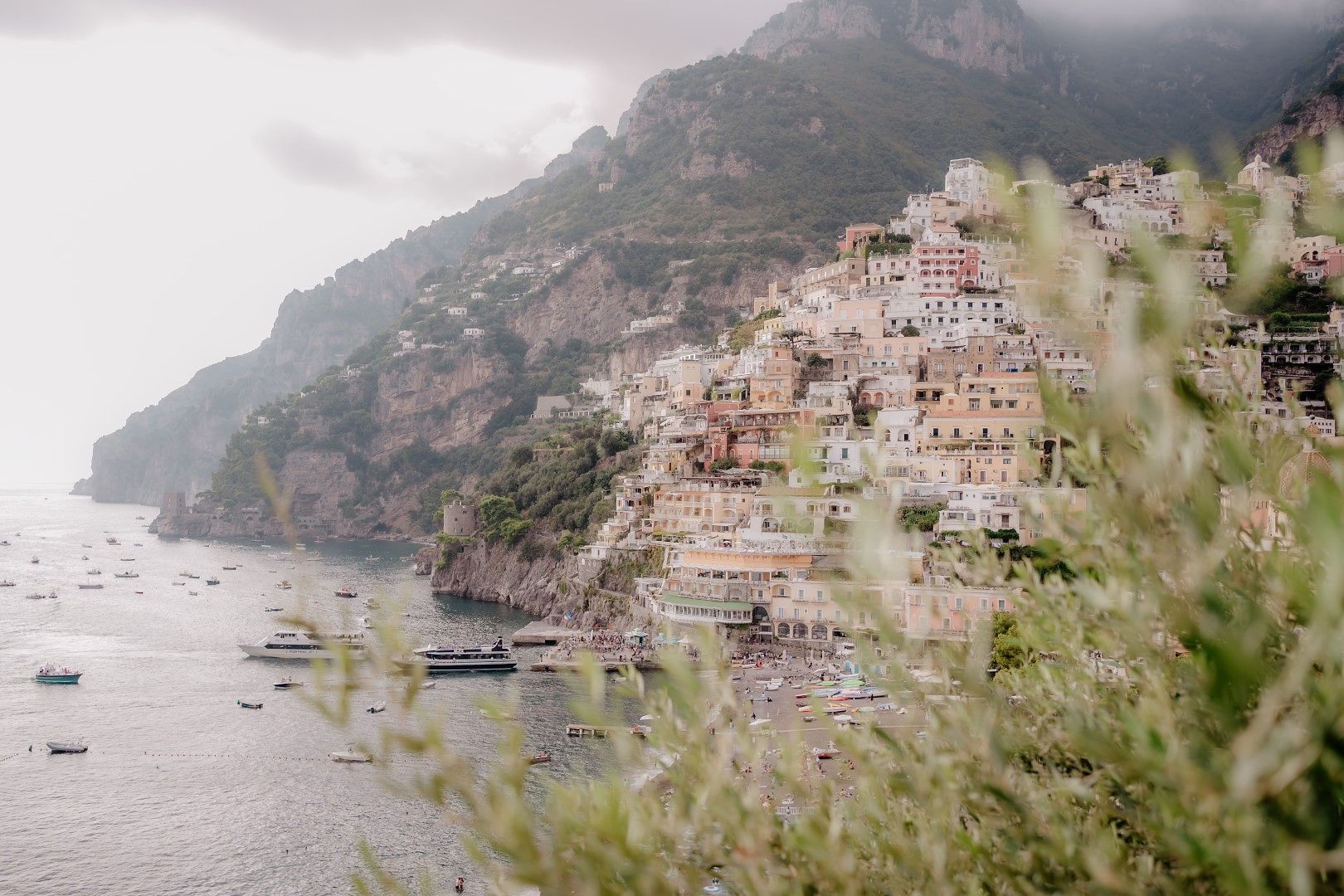 A wide shot of the pastel colored buildings perched on the hillside of Amalfi in Italy