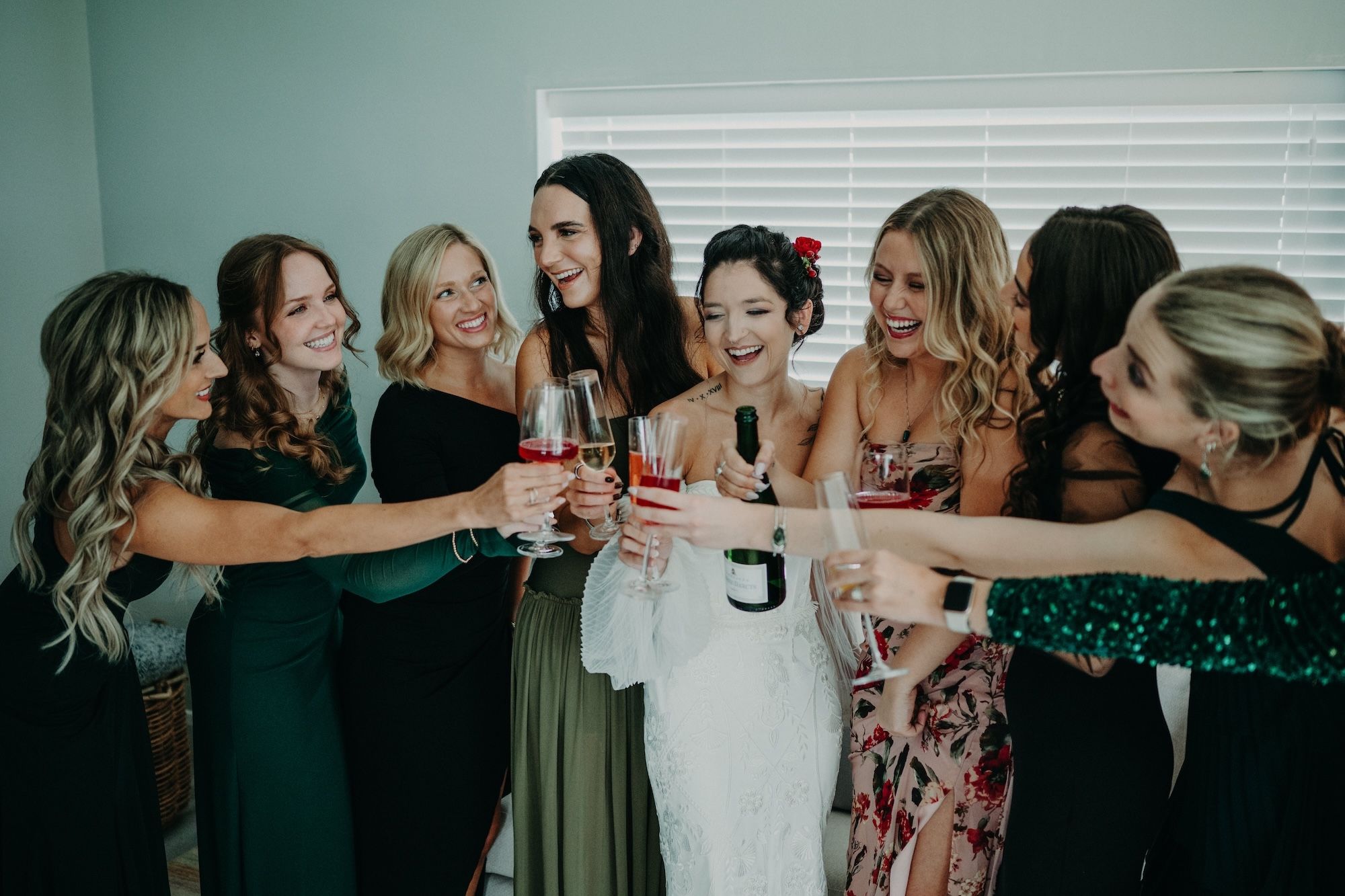 Bride celebrates and toast wine with bridesmaids while getting ready for the ceremony of her micro wedding in Ireland