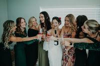 Bride celebrates and toast wine with bridesmaids while getting ready for the ceremony of her micro wedding in Ireland