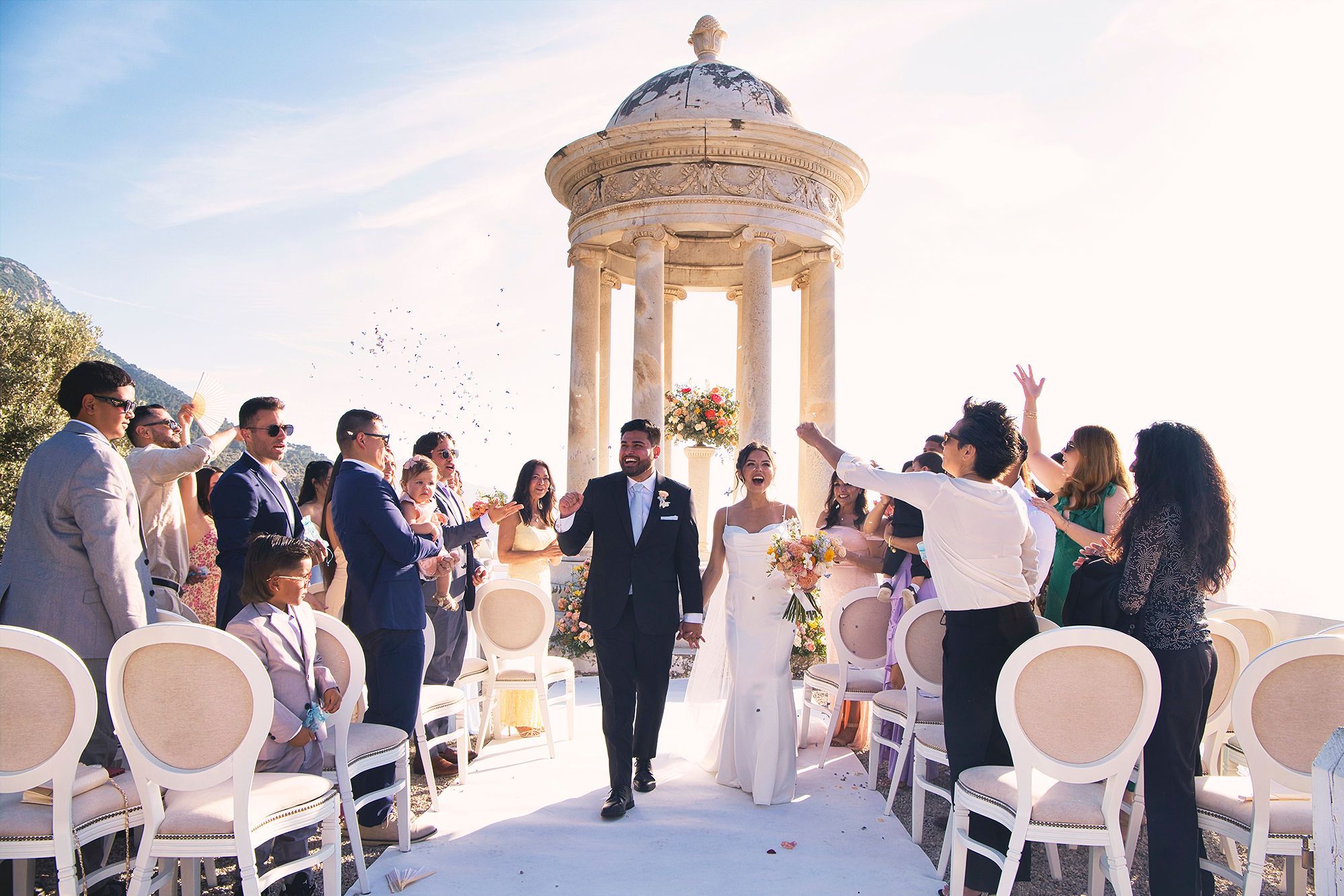 Bride and groom walking down the aisle in Mallorca as their guests cheered during their small wedding in Spain