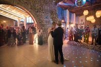 Bride and her father dance in the middle of a rustic reception room while everyone watches during a small wedding in Spain