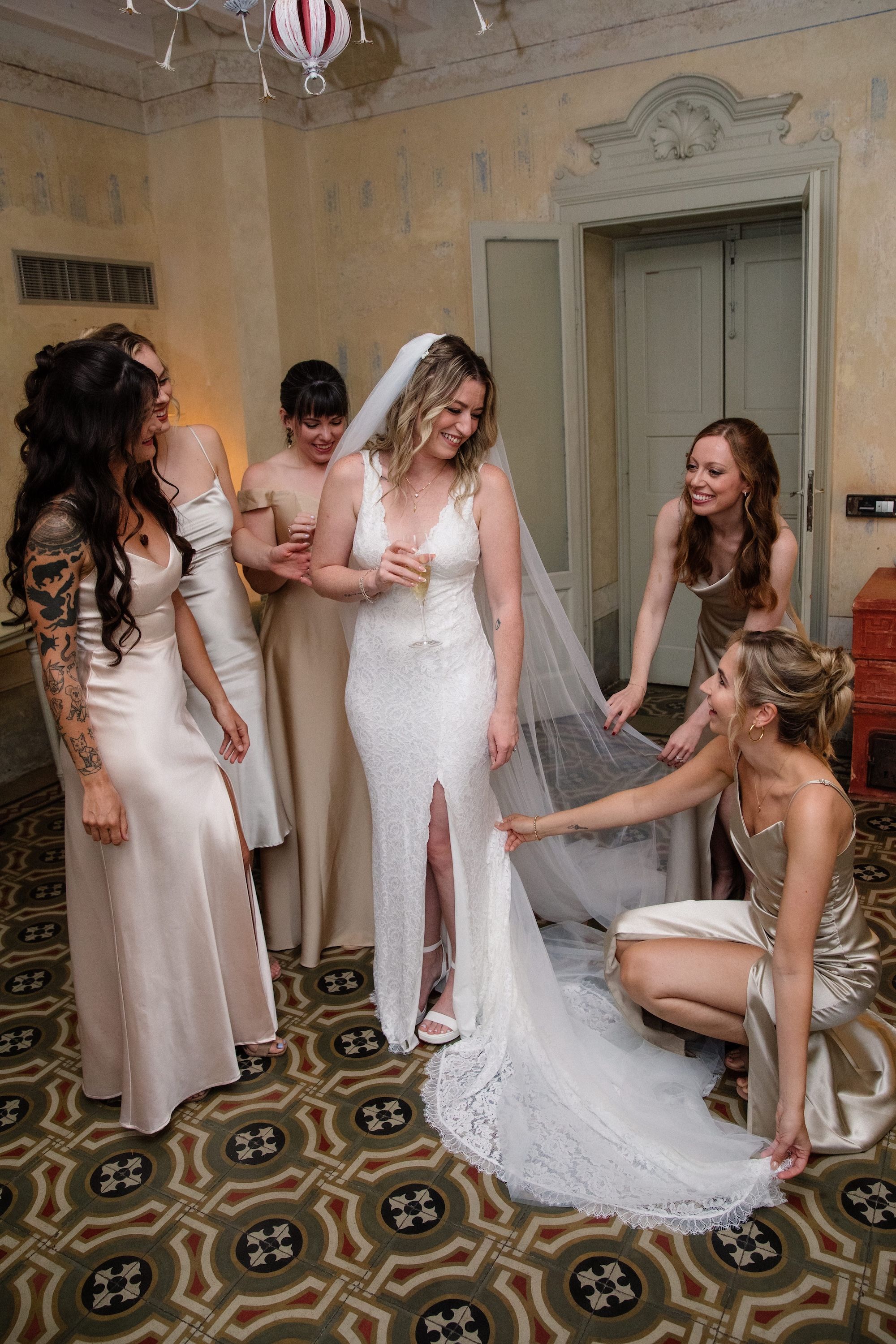 Bride having a light moment with her bridesmaids inside a villa in Como before her vow renewal ceremony in Italy