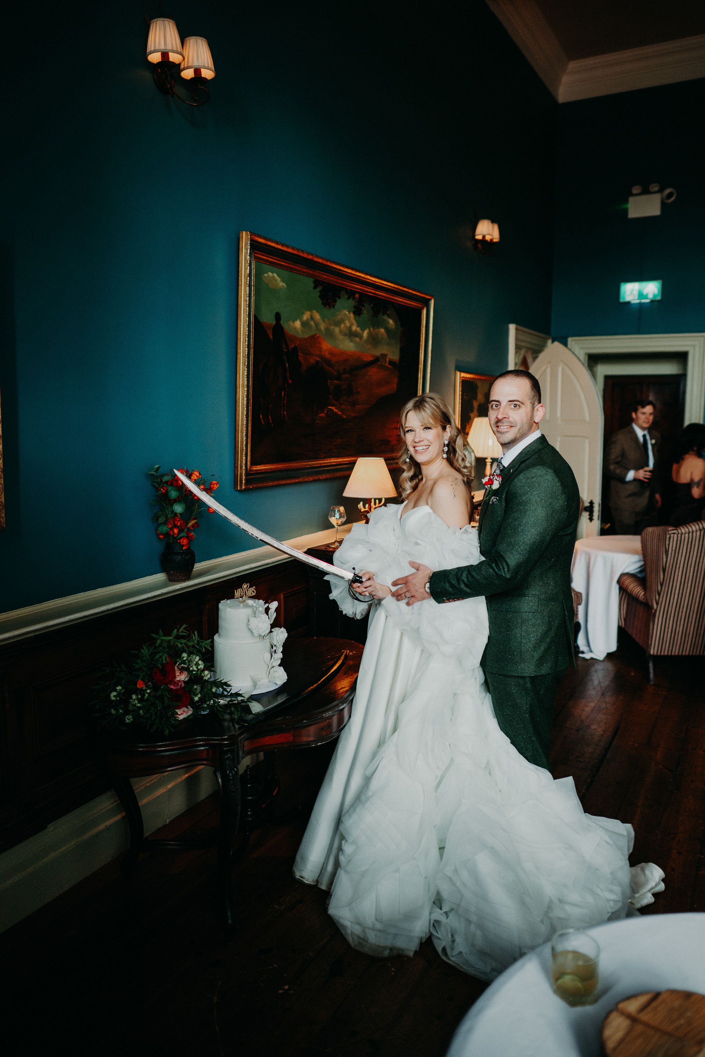 Couple cutting their wedding cake with a ceremonial sword at a small wedding in Ireland