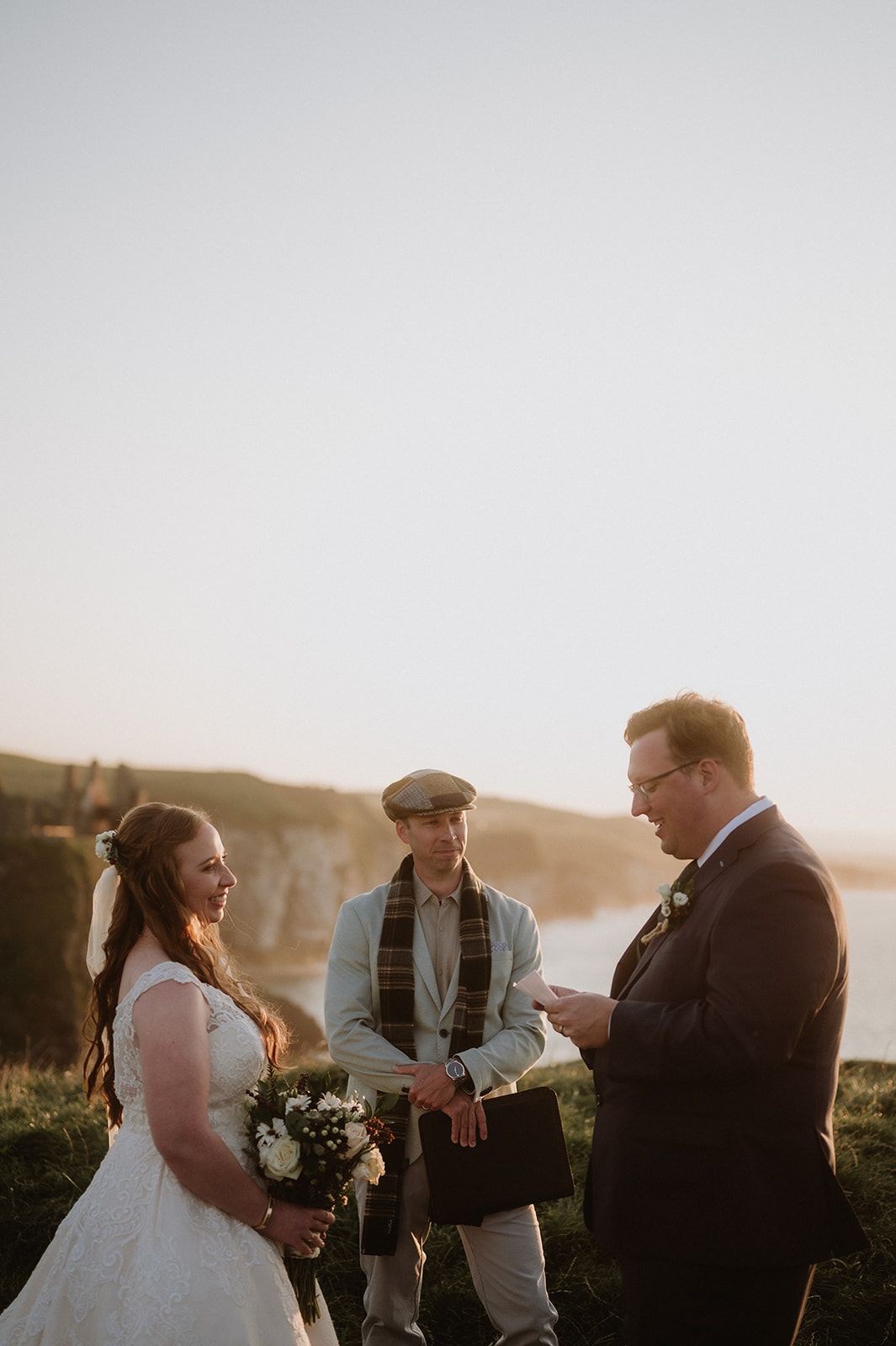 Groom recites his vows as he and his bride renew vows in Ireland with cliffs in the background