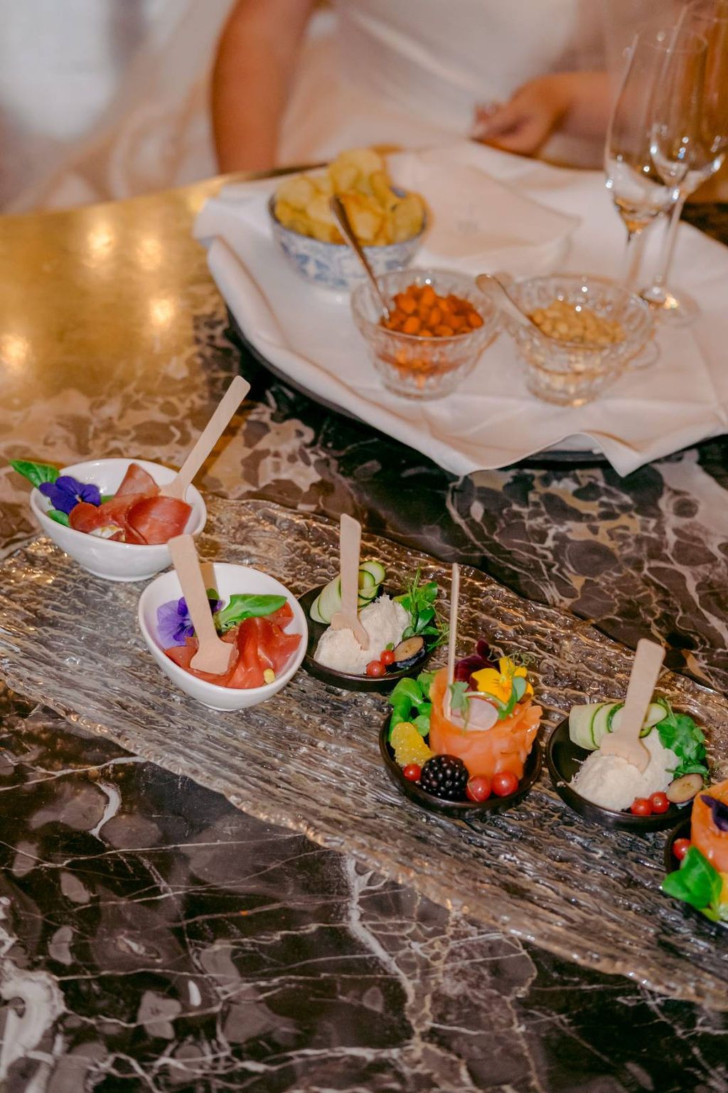 Delicious and colorful snacks in small bowls and plates arranged for a cocktail hour of a vow renewal in Italy