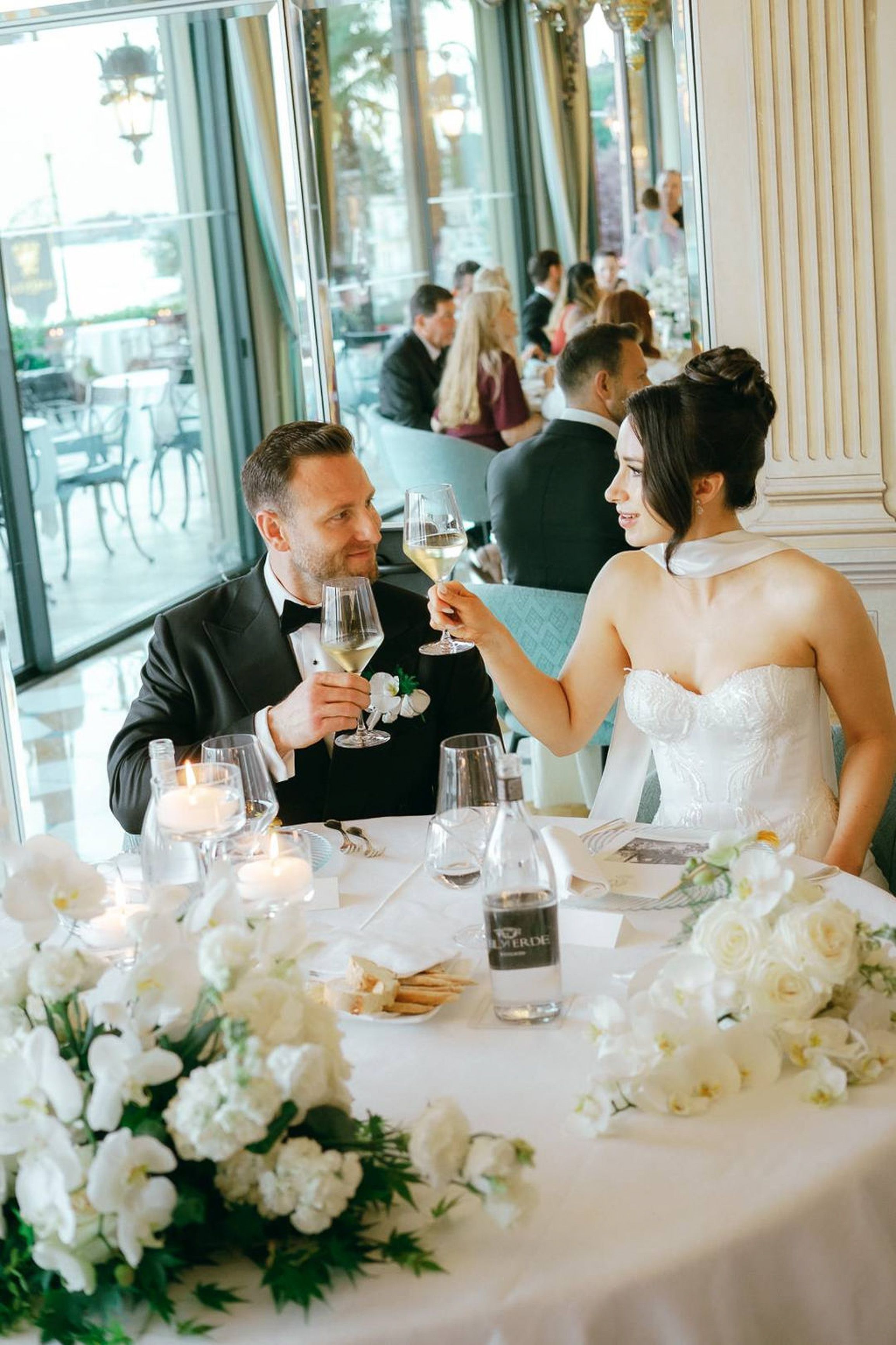 Newlyweds sharing a champagne toast during an intimate wedding in Italy reception