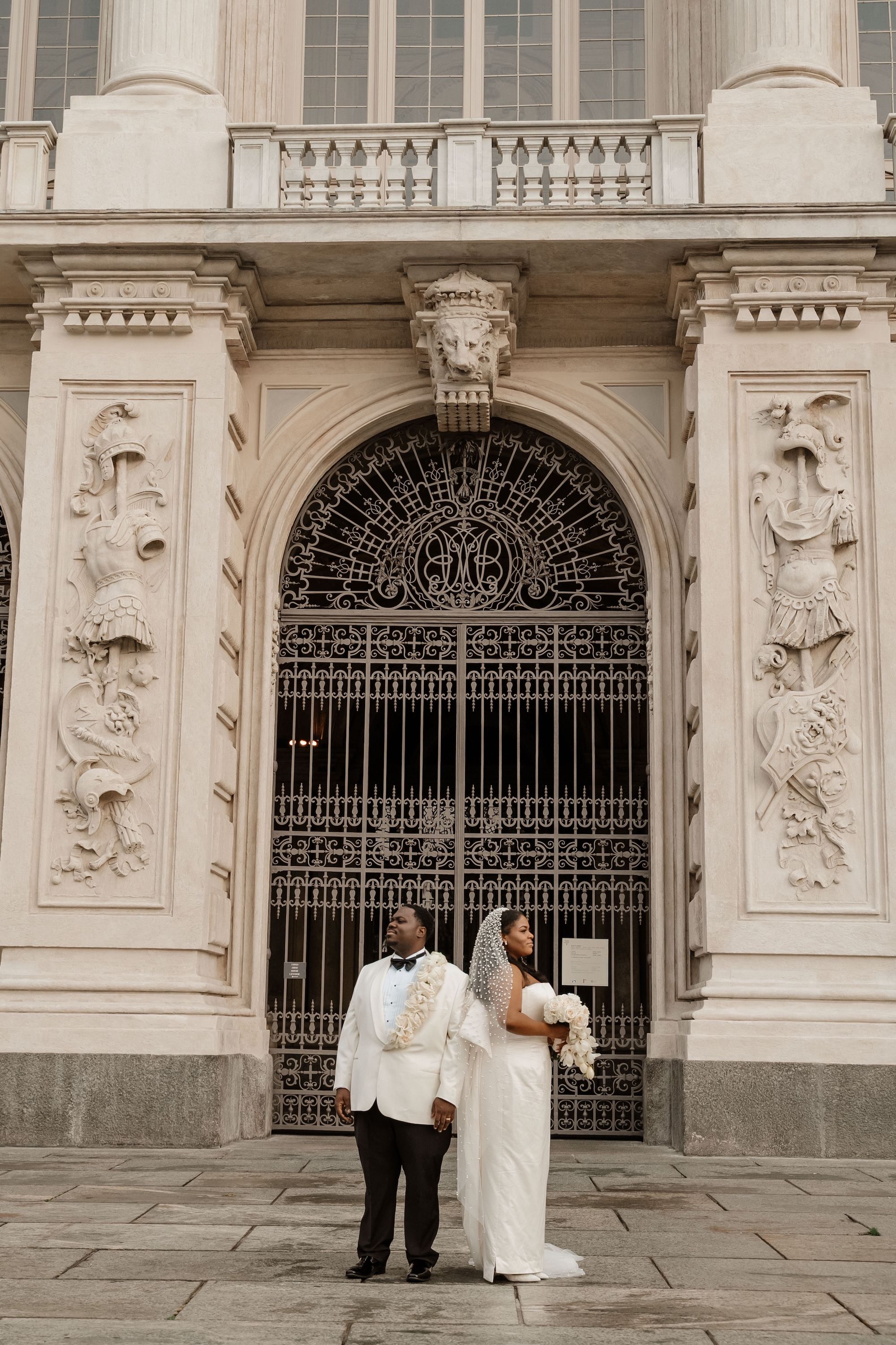 Newlyweds having a photoshoot outside the museum where they got married in Italy
