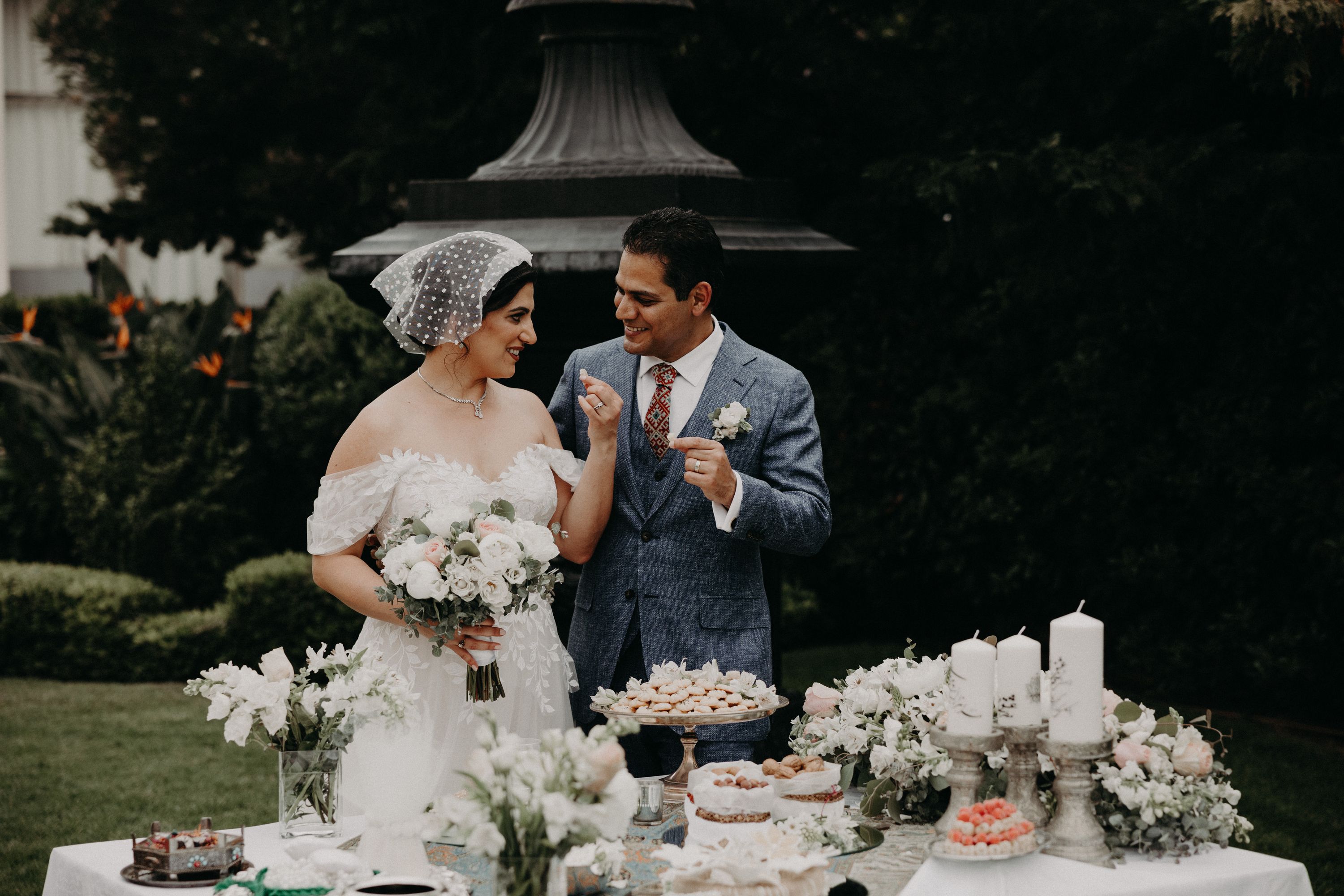 Bride tries to taste something with her groom beside her during their outdoor destination wedding ceremony in Portugal 